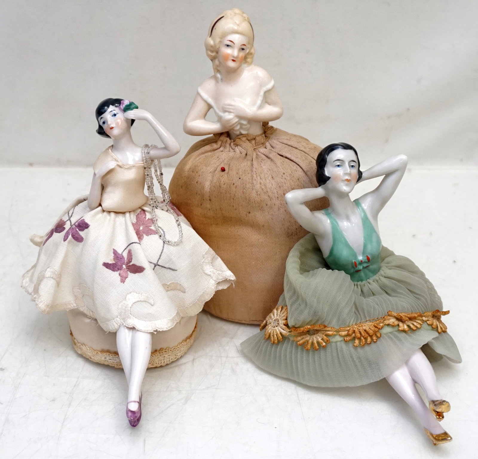 3 PORCELAIN PINCUSHION DOLLS: 2 Vintage Elegant 1920s-30s Porcelain Pincushion Dolls and one Seated Doll no pincushion. Tallest is 7". Weight on all 12 oz. PROVENANCE: A Private Charleston SC Estate.