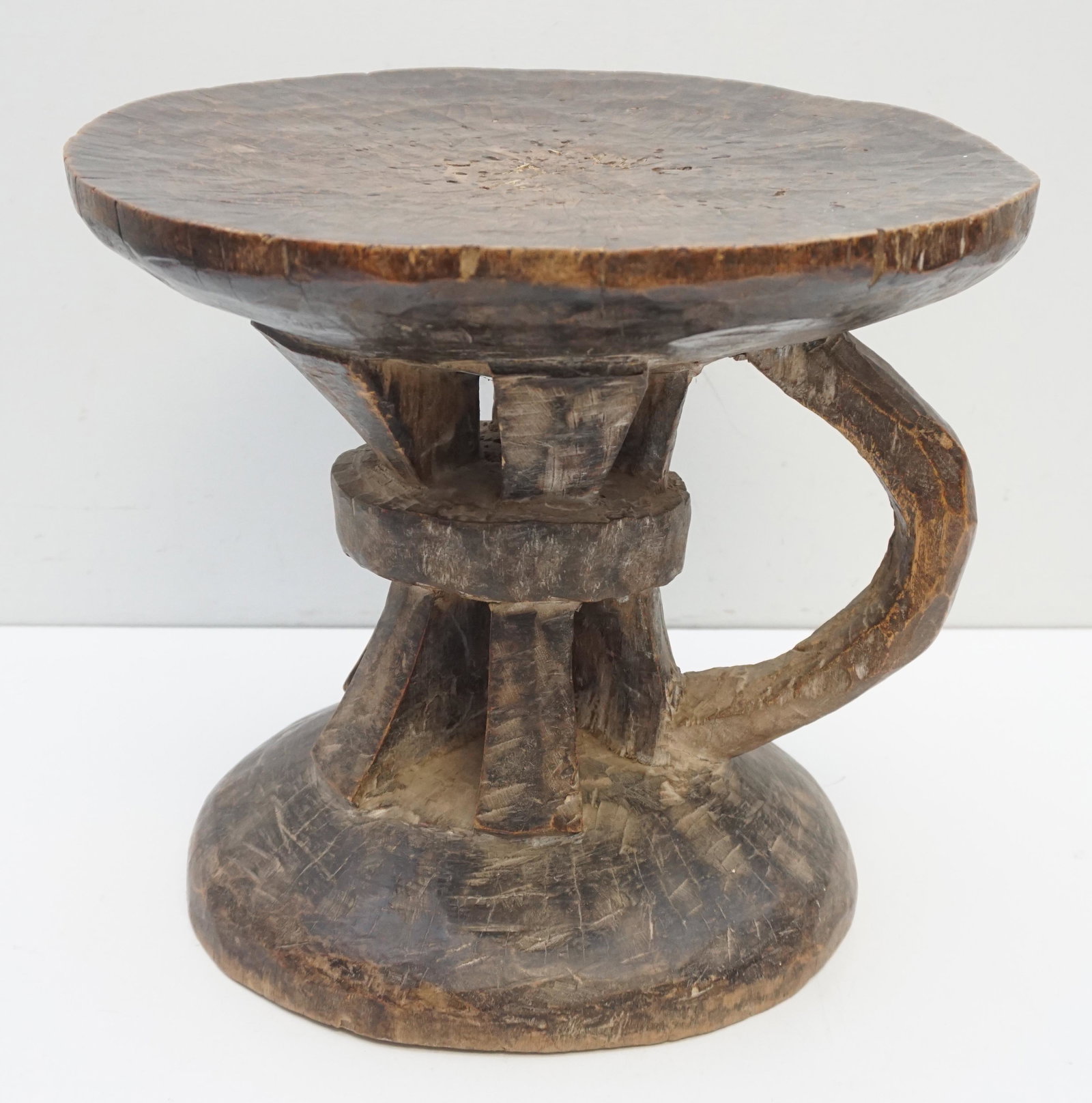 AFRICAN CARVED MILK STOOL: African Hand Carved Milk Stool, with handle. Measures 14"x14"x13". Weight 12 pds. PROVENANCE: The Estate of Senator Ernest F. Hollings, South Carolina. Ernest Frederick "Fritz" Hollings was born in Ch