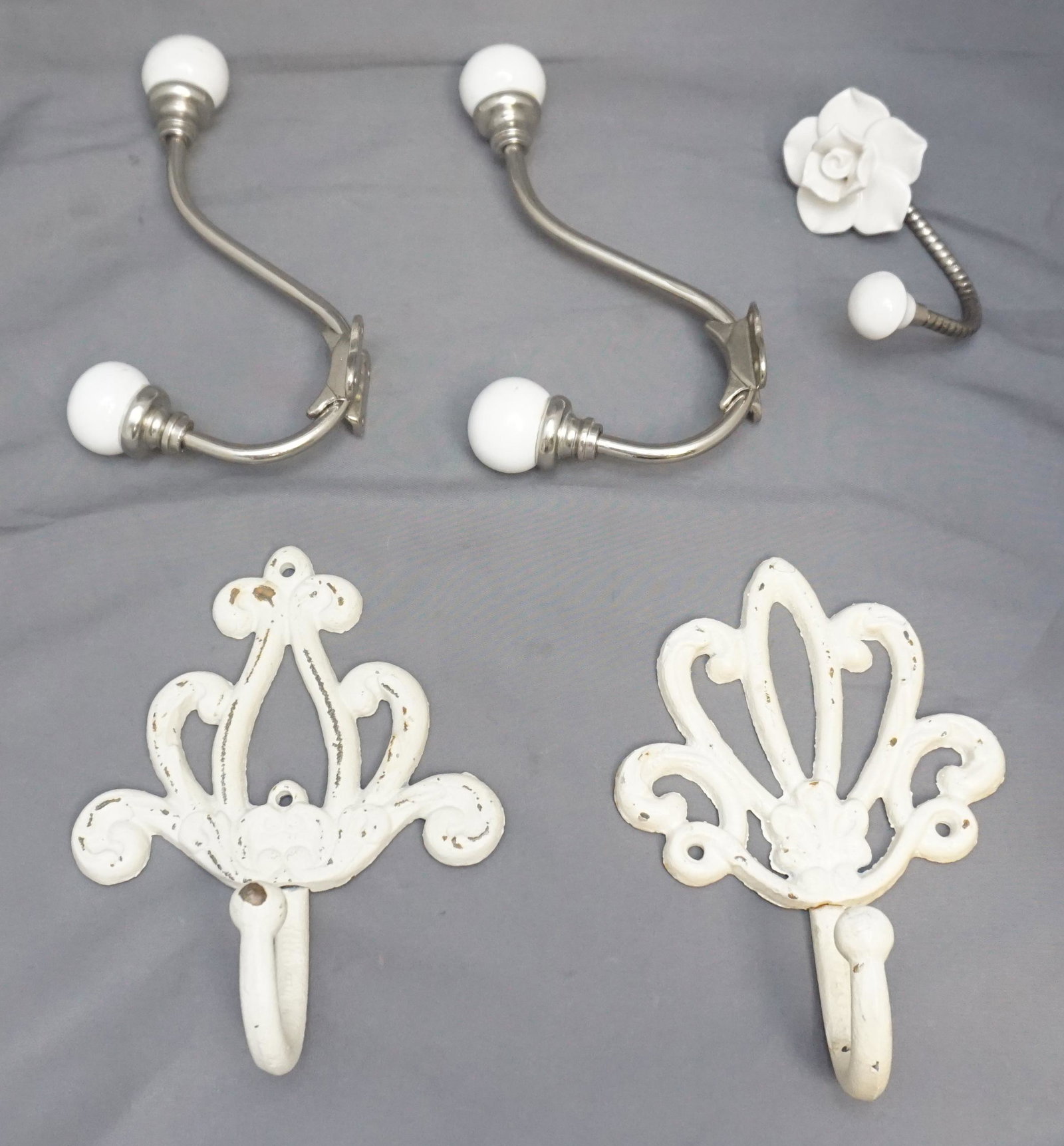 5 CAST IRON AND PORCELAIN WALL HOOKS: Five 20th c. Wall Hooks for Coats etc. 2 are cast iron in a antique finish 7". 2 are chrome with porcelain knobs 7" and 1 is a magnolia porcelain 3 1/2". Weight on all 2 pds 12 oz.