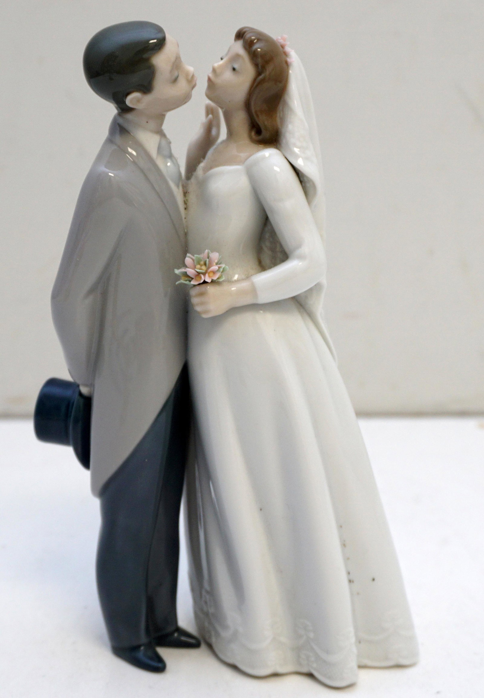 LLADRO BRIDE & GROOM CAKE TOPPER: Lladro porcelain bride and groom cake topper, A Kiss to Remember, #6620. Measures 7 1/2" tall. Weight 1 pd. PROVENANCE: A Private Charleston SC Estate