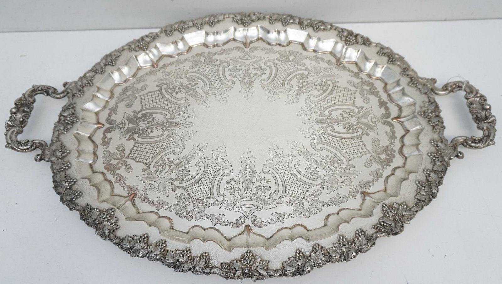 VICTORIAN SP BUTLERS TRAY GRAPES: Large Victorian Silver Plated Butlers Tray with Repousse Grape Rim and etched scroll and foliage. Measures 30"x20"x2 1/2". Weight 12 pds. PROVENANCE: Edwin Moore Brogdon, PhD, collection. Dr. Brogdon 