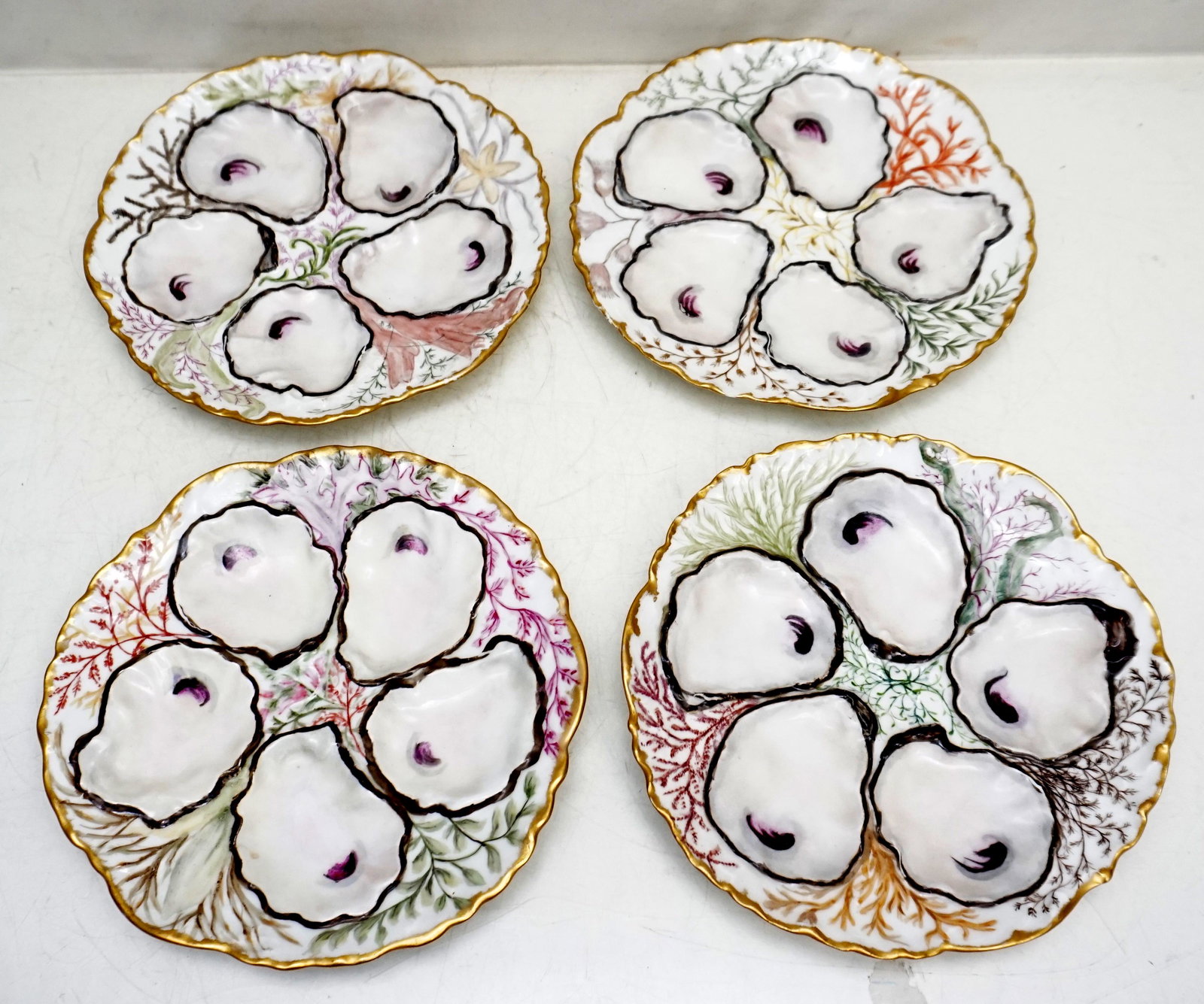 4 LIMOGES OYSTER PLATES SEA LIFE: Antique 4 William Guerin Porcelain 5 well oyster plates with hand painted sea life / marine motif, 8 1/2". Each different, seaweed and coral. Weight on all 3 pds 5 oz. PROVENANCE: A Private Charleston