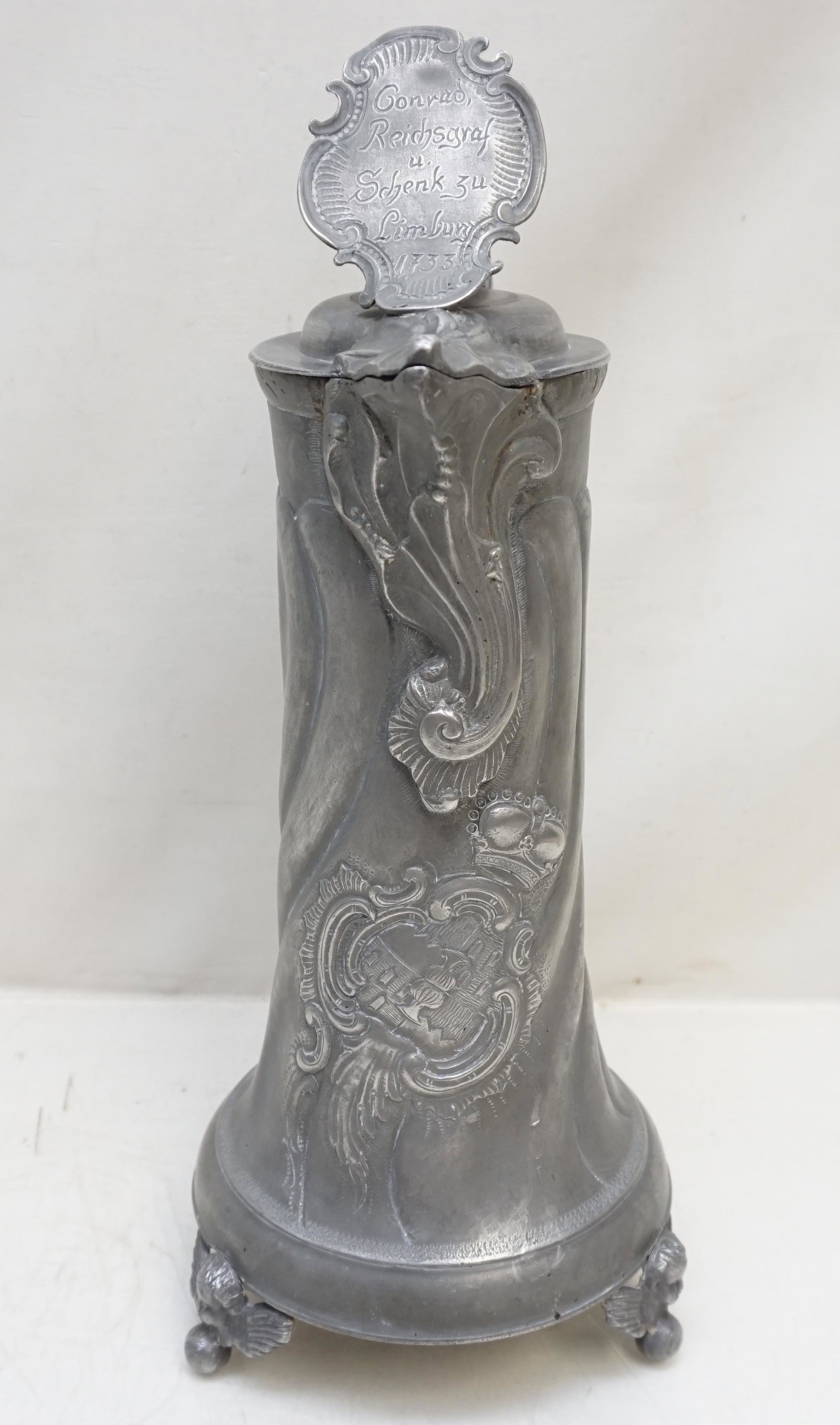 18TH C. STITZEN FORM PEWTER FLAGON: German Pewter Flagon Surmounted by a scrolled shield cartouche incised and dated 1733, with scroll thumbpiece, the tapering fluted cylindrical body with repousse scroll, castle and crown decoration, r