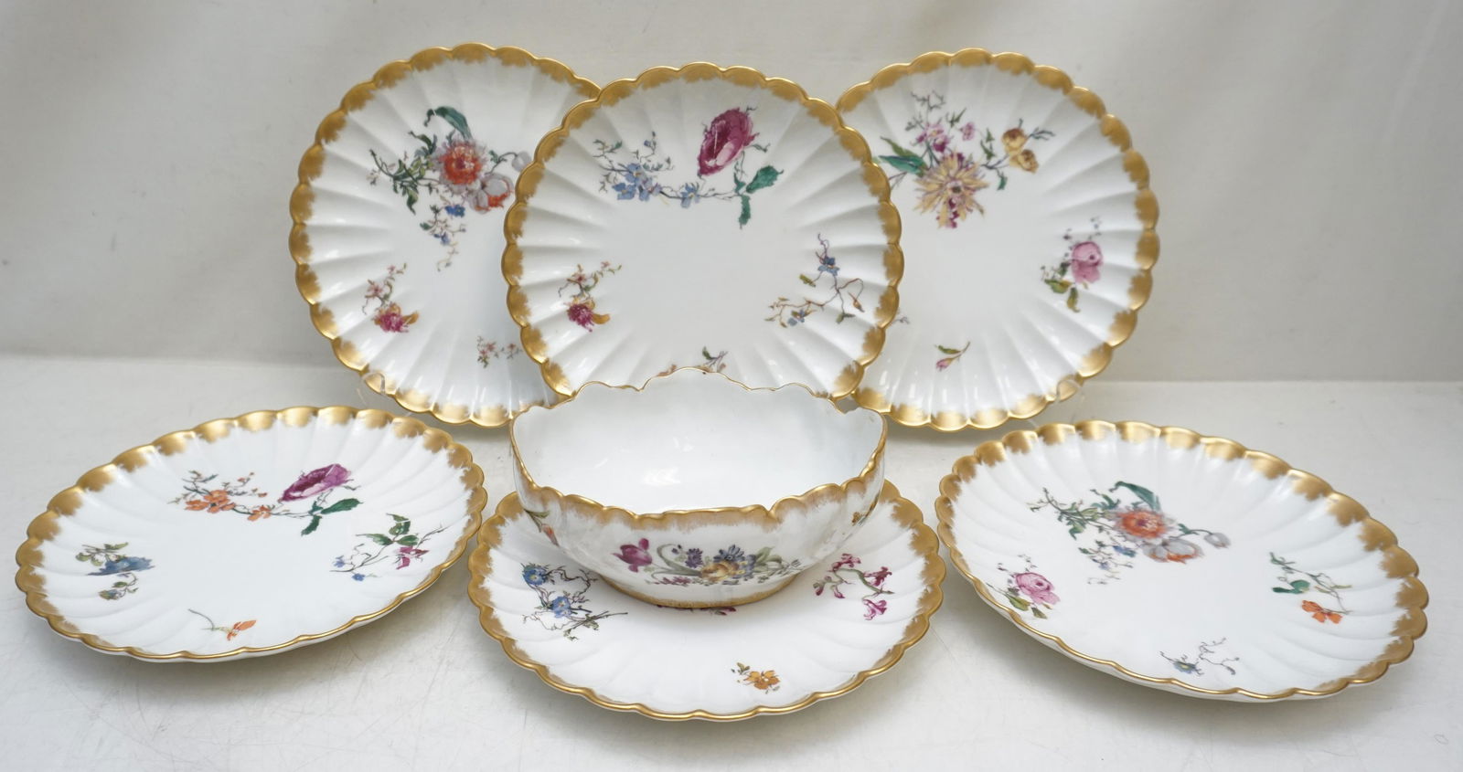 7 PC c 1887 LIMOGES DESSERT / LUNCHEON SET: 7 Piece Haviland & Cie Limoges French Porcelain Dessert Set. Mark used dates this set from c. 1887. Scalloped fluted various florals with gilt rims. Six plates 8 1/2"x8 1/2".. Oval Bowl 6 1/2"x4 3/4"x