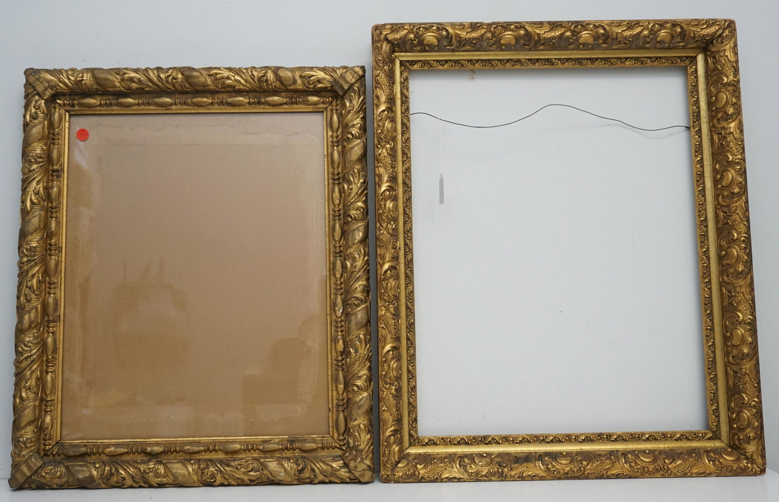 PAIR ORNATE ANTIQUE FRAMES: Pair of Antique Wood and Gesso Frames. Smaller with glass 20 1/2"x24 1/2"x1 3/4- Opening 15 1/2"x19 1/2". Large 22"x 27 1/2"x2 1/2". Opening 18"x 23". Weight on all 15 pds. PROVENANCE: A Charleston SC