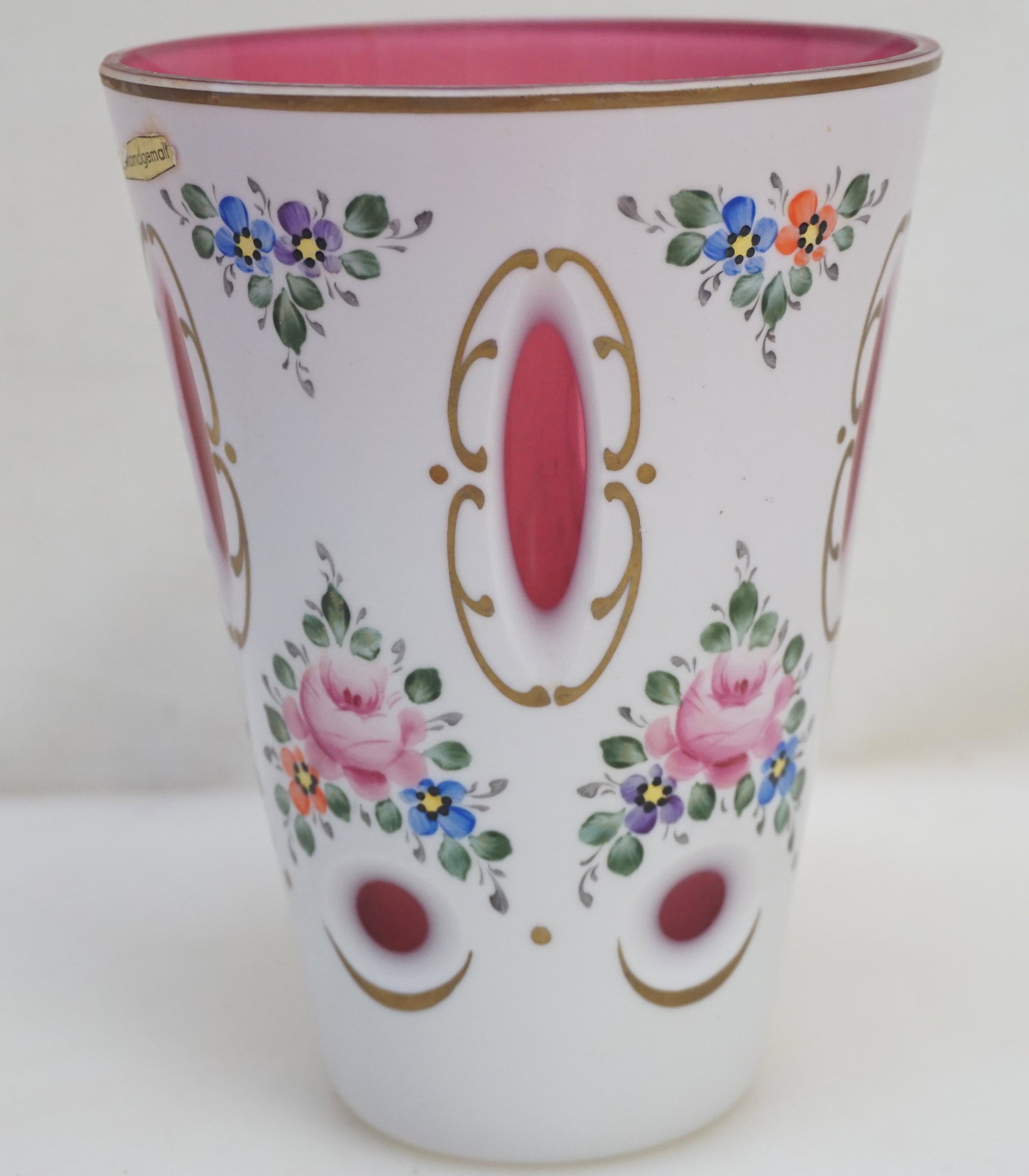 BOHEMIAN GLASS CUT TO CRANBERRY VASE: Vintage Czech Bohemian Cased Glass Vase, cut milk white to cranberry with hand painted floral decorations. Measures 4 1/2"x4 1/2"x6". Weight 1 pd 1 oz. PROVENANCE: A Charleston SC Private Estate
