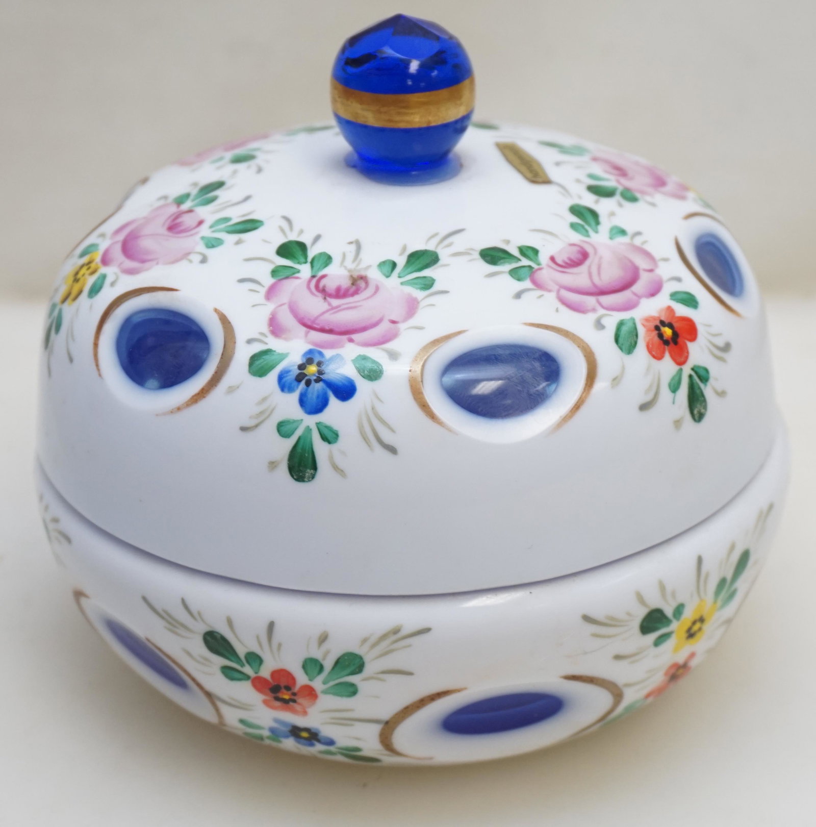 BOHEMIAN GLASS CUT TO BLUE CANDY: Vintage Czech Bohemian Cased Glass Covered Candy Dish, cut milk white to blue with hand painted floral decorations. Measures 5 1/2"x5 1/2"x5 1/4". Weight 1 pd 11 oz. PROVENANCE: A Private Charleston S