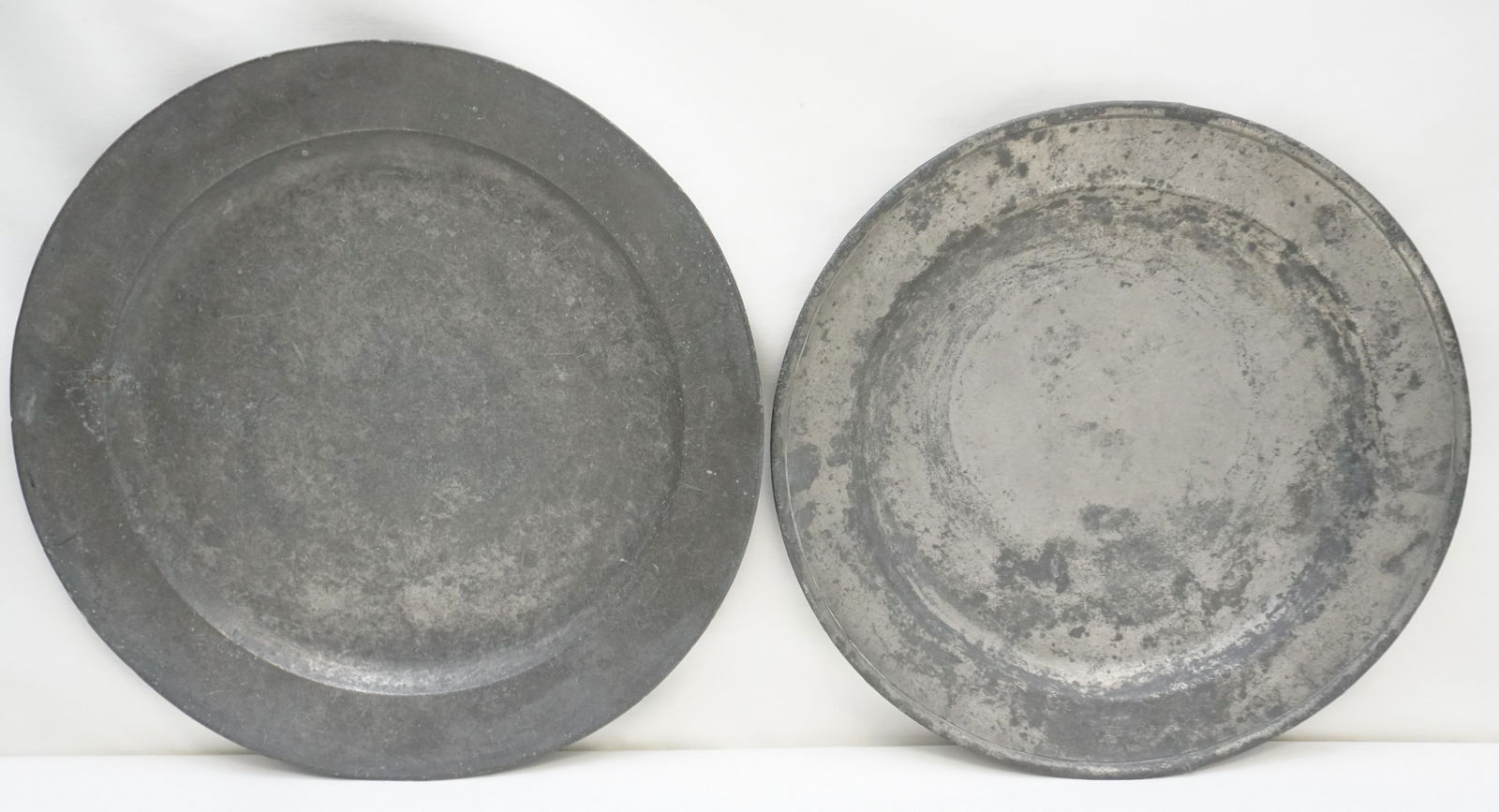 2 18th /19th c PEWTER CHARGERS: Two Antique 18th / 19th c. Large English Pewter Chargers / Trays. One 16 1/4" possibly Samel Ellis, cannot read marks, rim repaired. The smaller with boxed SE and other faint marks 15", small nick to