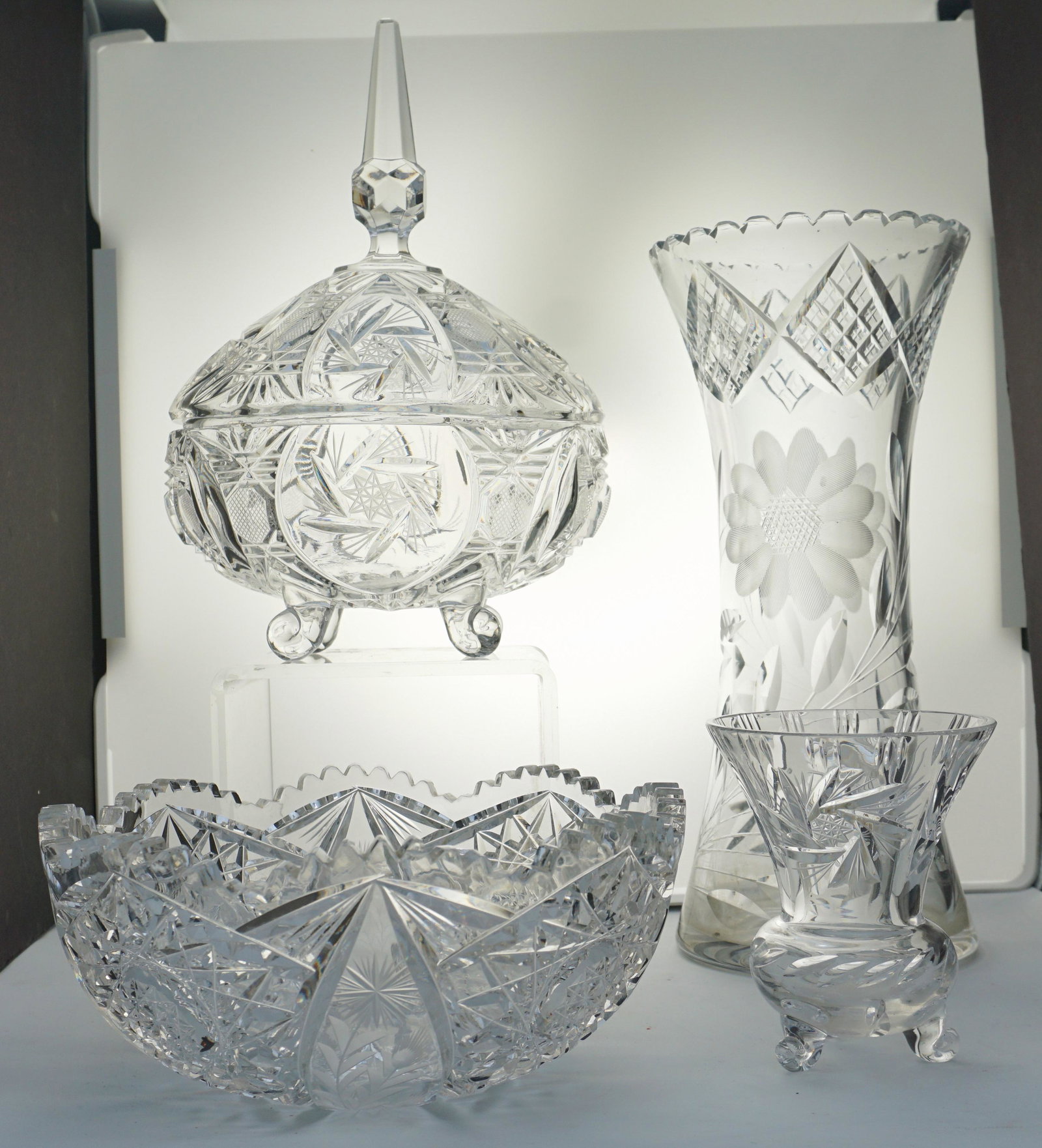 4 PC CUT CRYSTAL VASES - BOWLS: 1- Cut Lead Crystal Oval Candy Dish Footed with Lid 7" long 11" tall. 2- Tall Cut Crystal Vase with Etched Flowers 12". 3- Cut Grystal Bowl with Etched Flowers 8 1/4"x8 1/4"x3 1/2". 4- Small Footed Cu