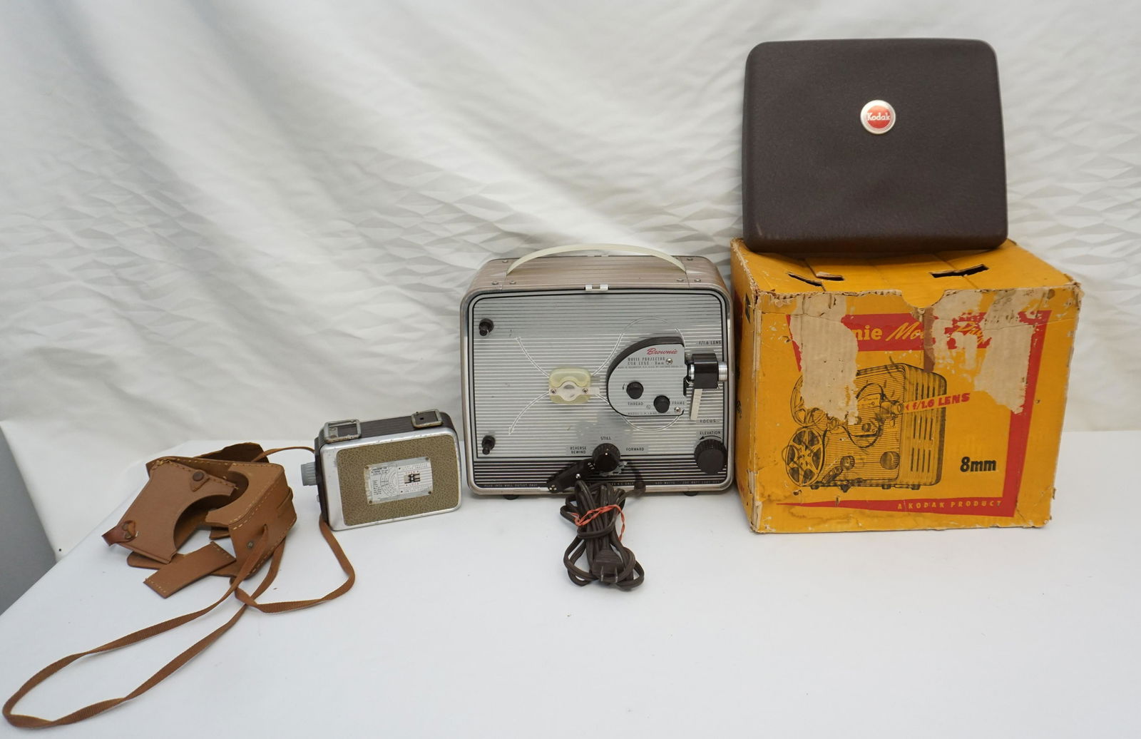 BROWNIE MOVE CAMERA + PROJECTOR: Vintage Brownie 8mm Movie Projector in the Original box and Brownie 8mm Movie camera. Box with Projector 12"x8 1/2"x10 1/4". Camera 5 1/2"x2 1/2"x4". Weight combined 14 pds 3 oz. PROVENANCE: A Charles