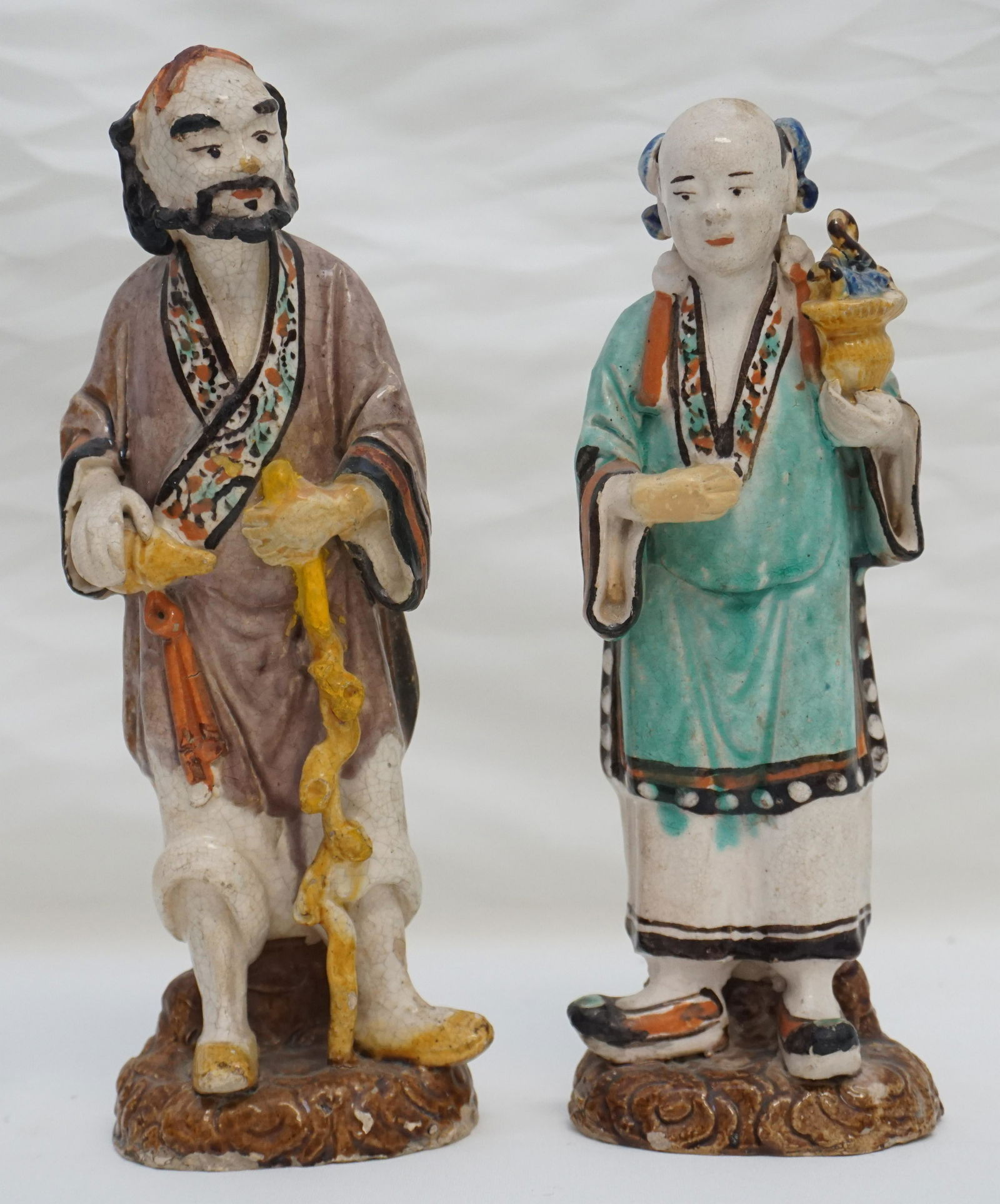 ANTIQUE CHINESE SANCAI POTTERY COUPLE: Older 19th c. Sancai Glaze Chinese Pottery Figurines. Man and woman, both on clouds. Perhaps Tomb Figurines. Each 10 1/4". Crazing, man has loss to glaze on back, nicks to bases. Weight on all 3 pds.