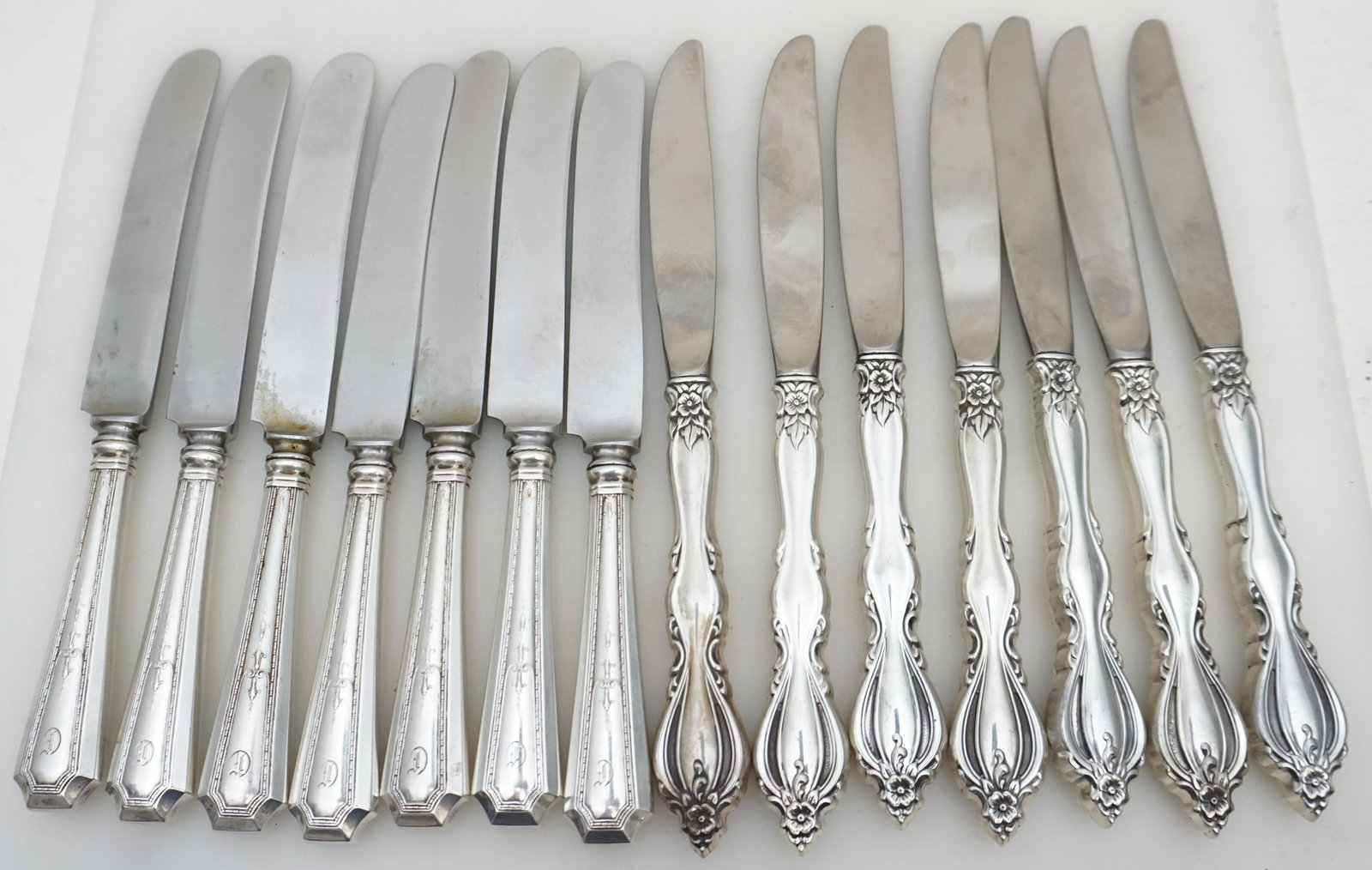 14 STERLING HANDLE DINNER KNIVES: 14 Sterling Handle Dinner Knives. 7 Durgin "Colfax" Old French Hollow Knife with Bolster, each 8 5/8". Monogrammed. 7 Ornate Floral Handle Knives, handles marked sterling, 8 3/4". No monograms, Weight