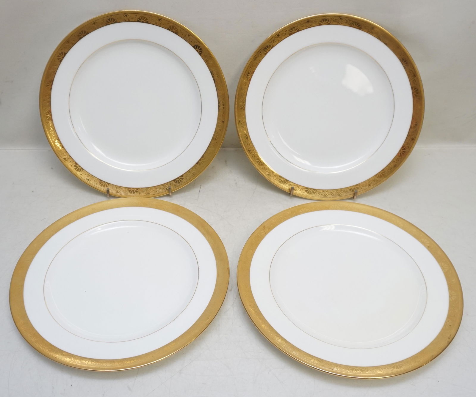 4 TIFFANY MINTONS LUNCHEON PLATES: Tiffany & Co, Minton English porcelain luncheon set of 4 plates, executed in bone white china with gold encrusted embossed banded rims. These were very popular at the time as they were often given as