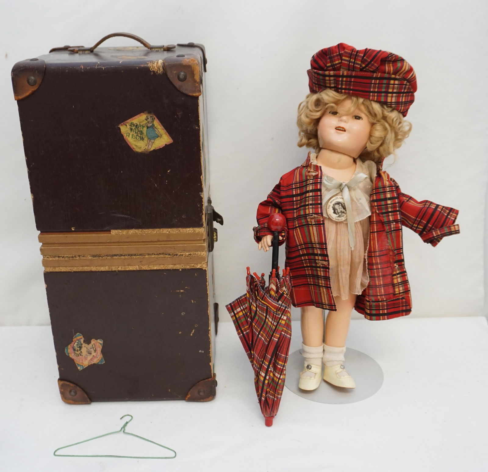 IDEAL SHIRLEY TEMPLE COMPOSITION DOLL w TRUNK: All original Ideal Shirley Temple Doll with Travel Trunk with stickers and additional Shirley Temple Plaid Raincoat, Hat and Umbrella . Dressed in a "Baby Take a Bow Dress". Composition socket head on