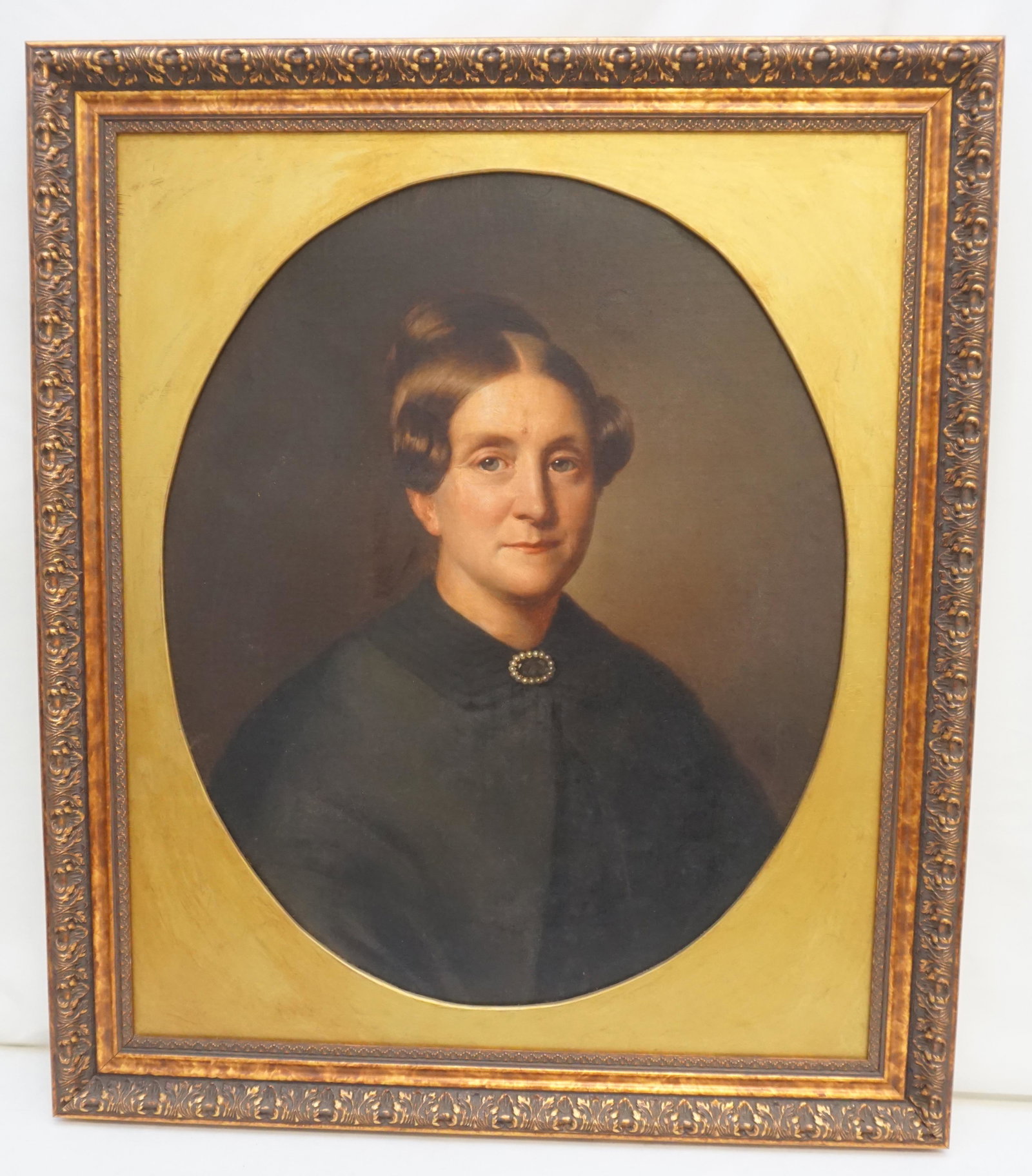 19th c AMERICAN LADY IN MOURNING PORTRAIT: 19th c. American Oil on Canvas Exceptional Oval Portrait of a Lady in Mourning. In black dress and cloak with Pearl and Jet Brooch. Fine Details. In gilt wood frame. No signature. In frame measures 29