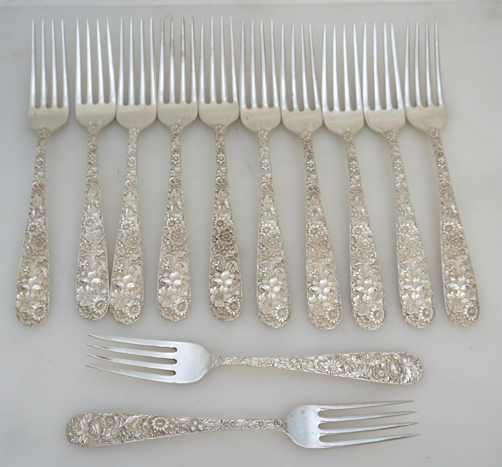 12 KIRK STERLING REPOUSSE SILVER FORKS: 12 Repousse 1828 Sterling Silver Forks by S. Kirk & Son. 10 are the large 7 7/8" size and 2 are 7 1/4". All are monogrammed on the backs. Approximate silver weight on all 820 grams. The iconic Repouss
