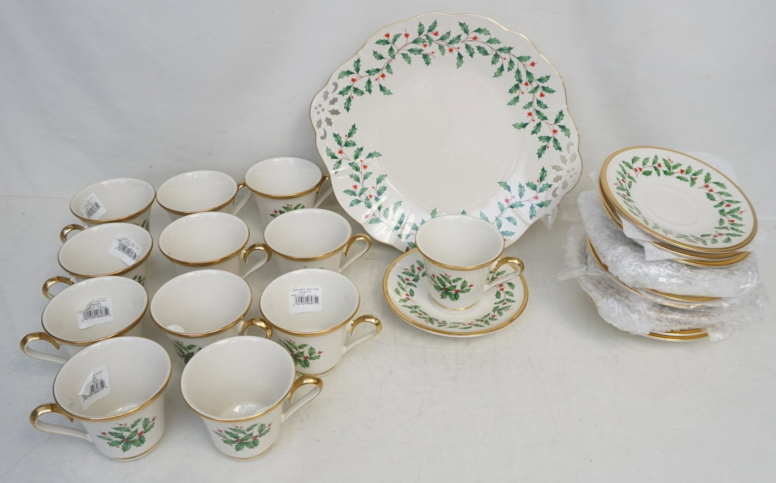 25 LENOX HOLIDAY CUPS - SAUCERS - CAKE PLATE: Twelve (12) Holiday (Dimension) Fine Bone China Footed Cups 3", Twelve (12) Holiday (Dimension) Fine Bone China Saucers 6" and 1 Holiday (Dimension) Fine Bone China Cake / Cookie Plate with Pierced Ha