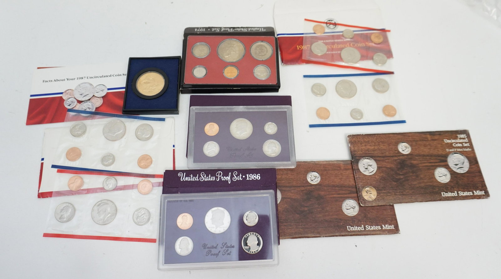LOT AMERICAN PROOF SETS COINS: United States 1974 and 1980s. 1- 1987 Uncirculated Coin Set. 2- 1987 Uncirculated Coin Set. 3- 1985 Proof Set. 4- 1986 Proof Set. 5- 1985 Uncirculated Coin Set.6- 1985 Uncirculated Coin Set. 7- 1974 P