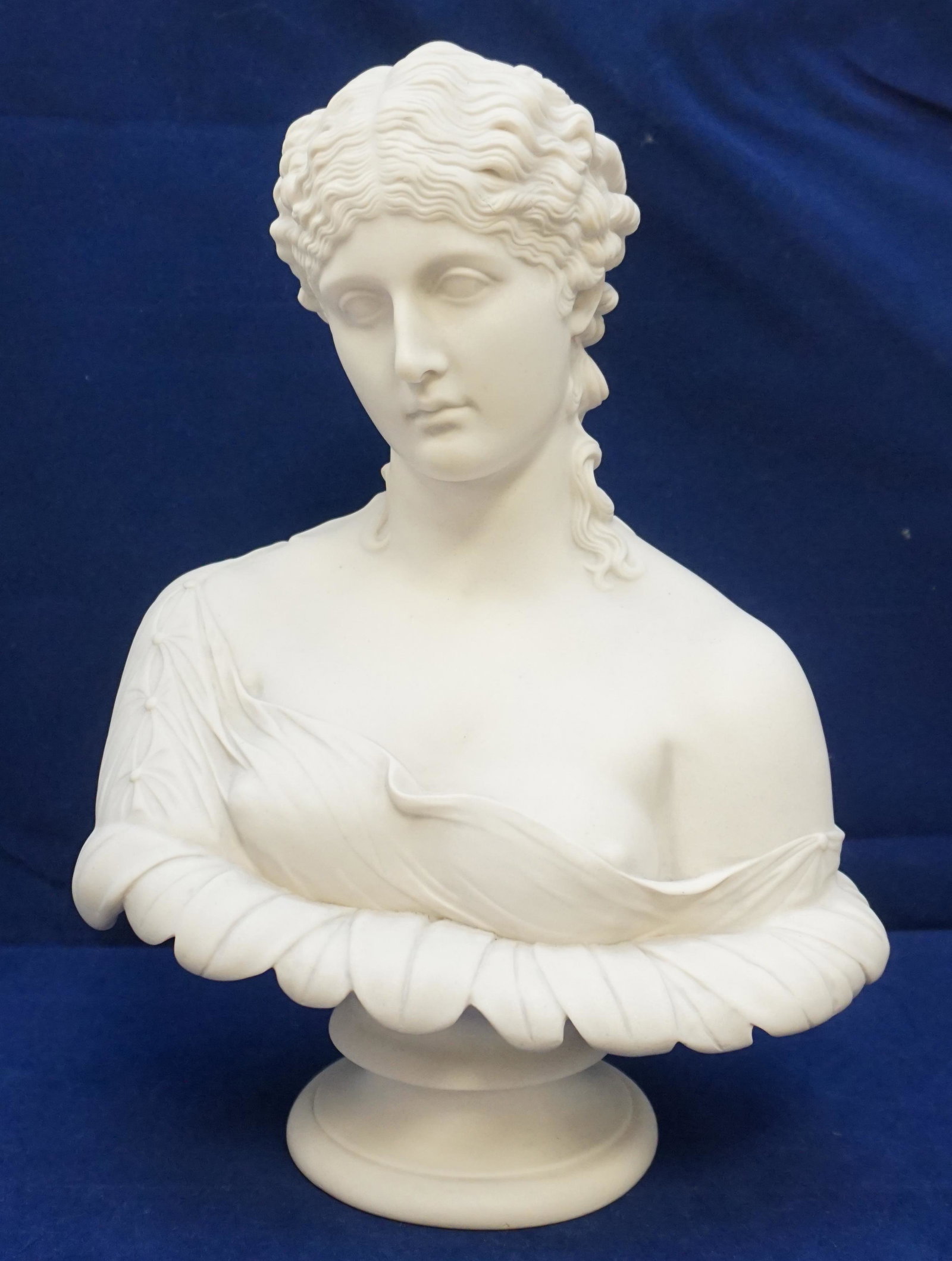 PARIAN TYPE BUST CLYTIE DELETTAUTI: Parian Type Molded Bust of Clytie mounted atop a waisted circular socle.stamped "Delettauti". After the Antique, modelled by C. Delpech for the Art Union of London, the nymph with downcast face and sc