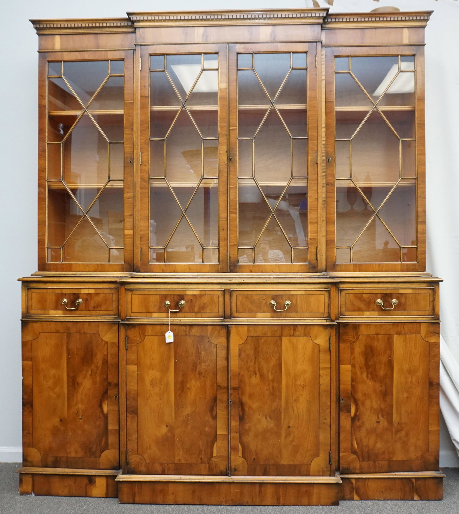 GEORGIAN FRUITWOOD BREAKFRONT BOOKCASE: Georgian Style Fruitwood Breakfront / Bookcase. The molded cornice above four glazed cabinet doors with lattice mullions, each above a single drawer and cabinet doors. Measures approximately 71"x16"x8