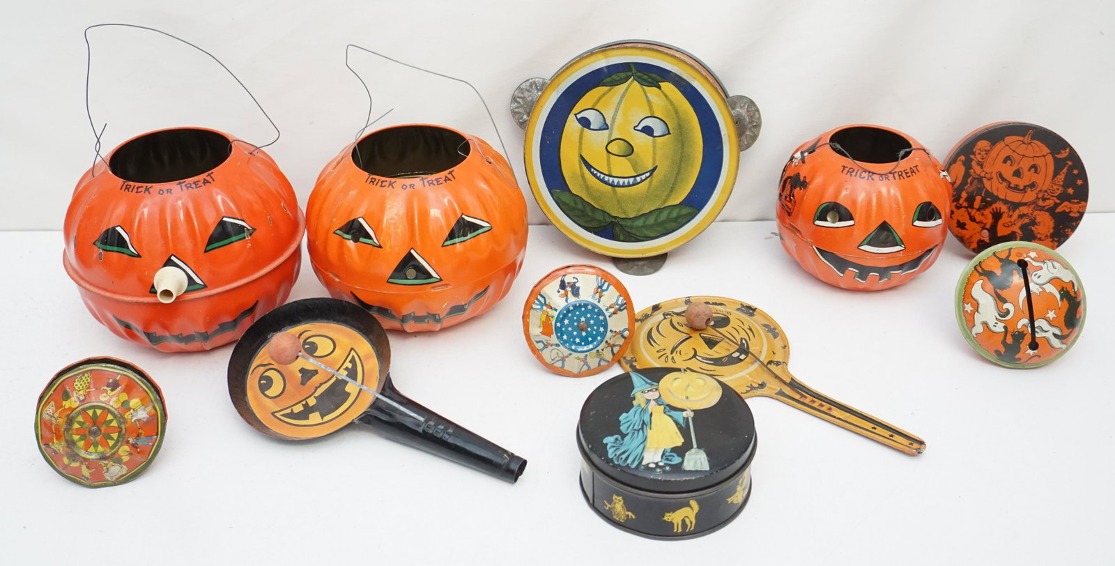 12 VINTAGE TIN LITHO HALLOWEEN PUMPKINS + NOISEMAKERS: All are 1930-50s Tin Litho Halloween. 1-Old Tin Litho Halloween Pumpkin with working Whistle Nose made U.S. Metal Toy Mfg. Co. 6" tall. 2- Old Tin Litho Halloween Pumpkin Face Tambourine Noisemaker 6 