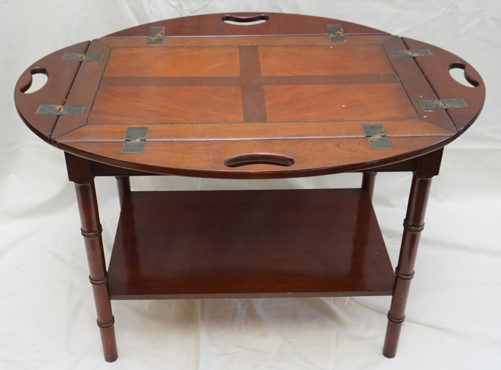 MAHOGANY BUTLERS TABLE TEA CART: Hinged Mahogany Butler's Tray Table Tea Cart. Hinged lift up leaves with brass hardware. Original caster wheels in drawer. Label from Mahogany Association in drawer. Measures 29 1/2"x19 1/2"x29" Tall 