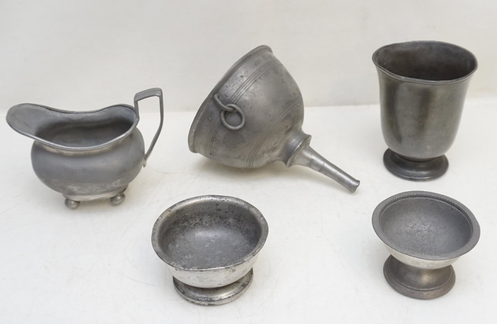 5 pc ANTIQUE 18th c PEWTER ITEMS: All are Antique Pewter. 1- Antique Pewter Funnel with hang ring. 2- Antique Beaker 4". 3- Antique Pewter Sauce 4" long. 4- Antique Pewter Pedestal Salt 2 1/4" wide. 5- Antique Pewter Pedestal Salt 3" 