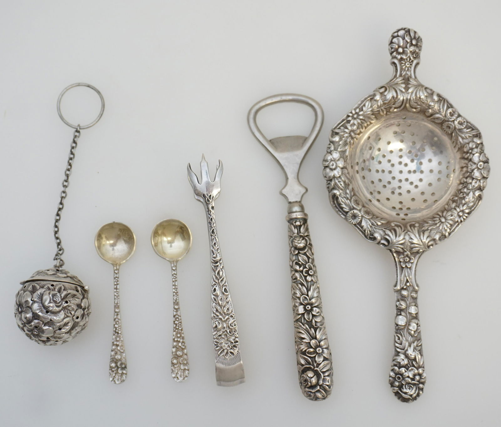 5 STERLING REPOUSSE S. KIRK TEA +: All are S. Kirk Sterling Silver Repousse. 1- Over the cup Tea Strainer 6 1/2". 2- Tea Ball 1 1/4". 3- Claw Sugar Tongs 4". 4- Two (2) Salt Spoons 2 3/4". 5- Sterling Handle Bottle Opener 5 1/2". Weigh