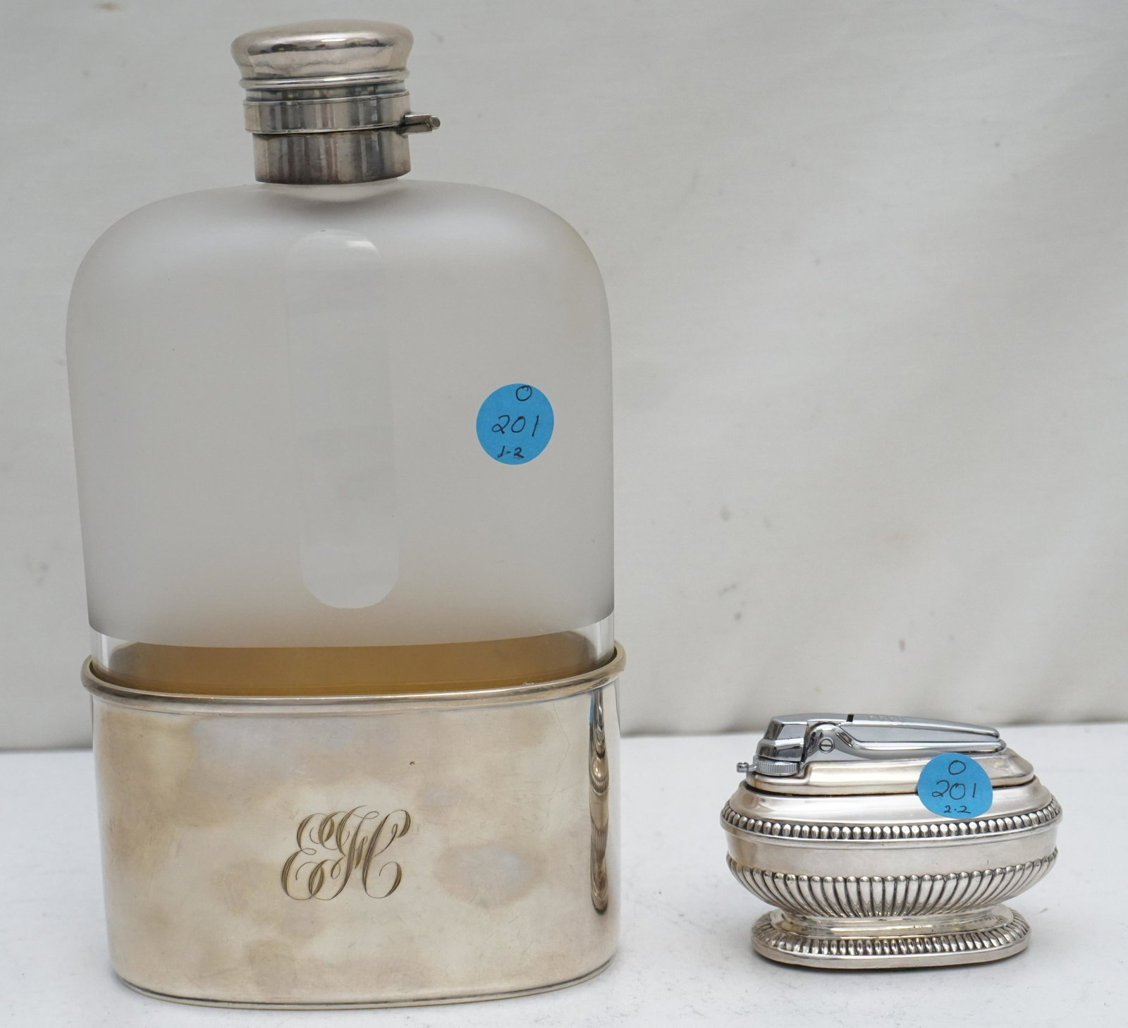 LARGE SILVER PLATED FLASK + TABLE LIGHTER: 1- Large Gorham early 20th c. Silver Soldered 1 Quart Flask.Monogrammed. Measures 5"x2 1/4"x9 1/2". Cap needs to be reglued. 2- Ronson Silver Plated Table Lighter 3 1/4" long, good condition. Weight o