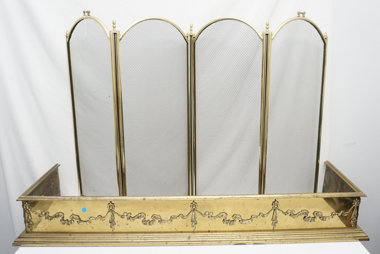 FRENCH POLISHED BRASS FIREPLACE FENDER + SCREEN: Antique Louis XVI style polished brass fireplace fender 48 1/2", purchased on King Street, Charleston. Four panel folding screen 34". NO IN HOUSE SHIPPING. PROVENANCE: A Private Charleston SC Estate.*