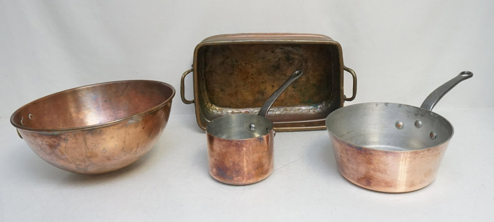 4 pc FRENCH COPPER COOKWARE: Early 20th c French copper cookware 4 Piece, Small sauce Pan with Spout. 4 1/2"w and 3 1/4"hx9 1/4"l. Pot 8"wx3 1/2"hx15"l. Copper Mixing Bowl, Brass Hanging Ring.10 1/4"x10 1/4"x5". 19th c. Brass Cop