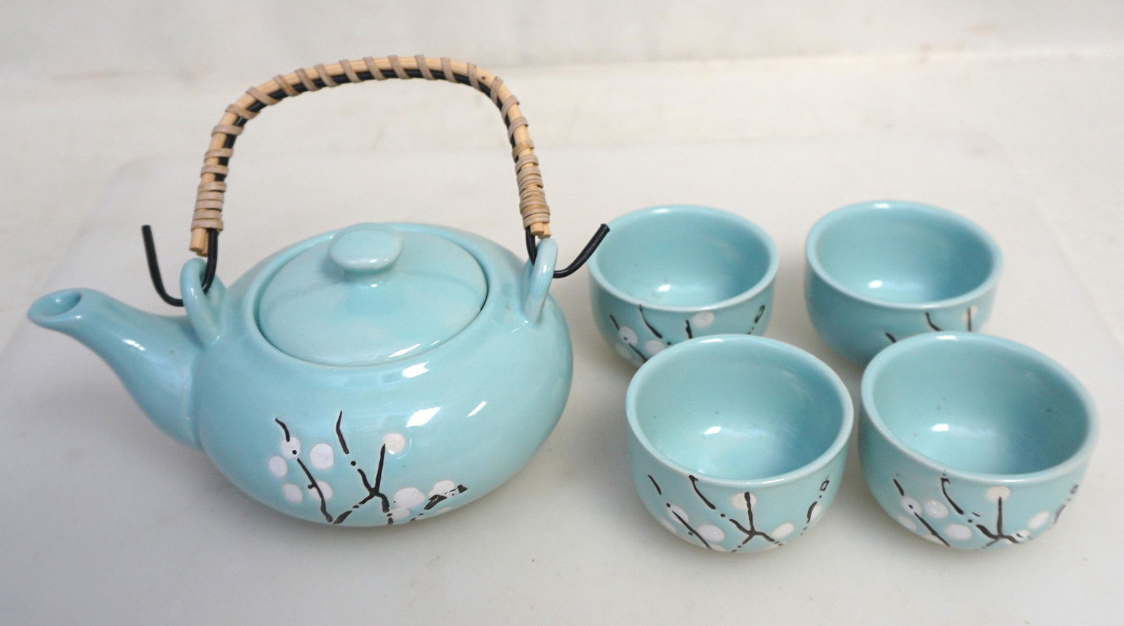 CHINESE CELADON TEA SET: 20th c. Chinese Traditional Hand Painted Longquan Celadon tea set. White Blossoms. Tea Pot and 4 Cups. In the original wood box. Teapot 5 1/2" long.Cups 2 1/8" wide and 1 1/2" high. Wood Box 8 1/2"x5