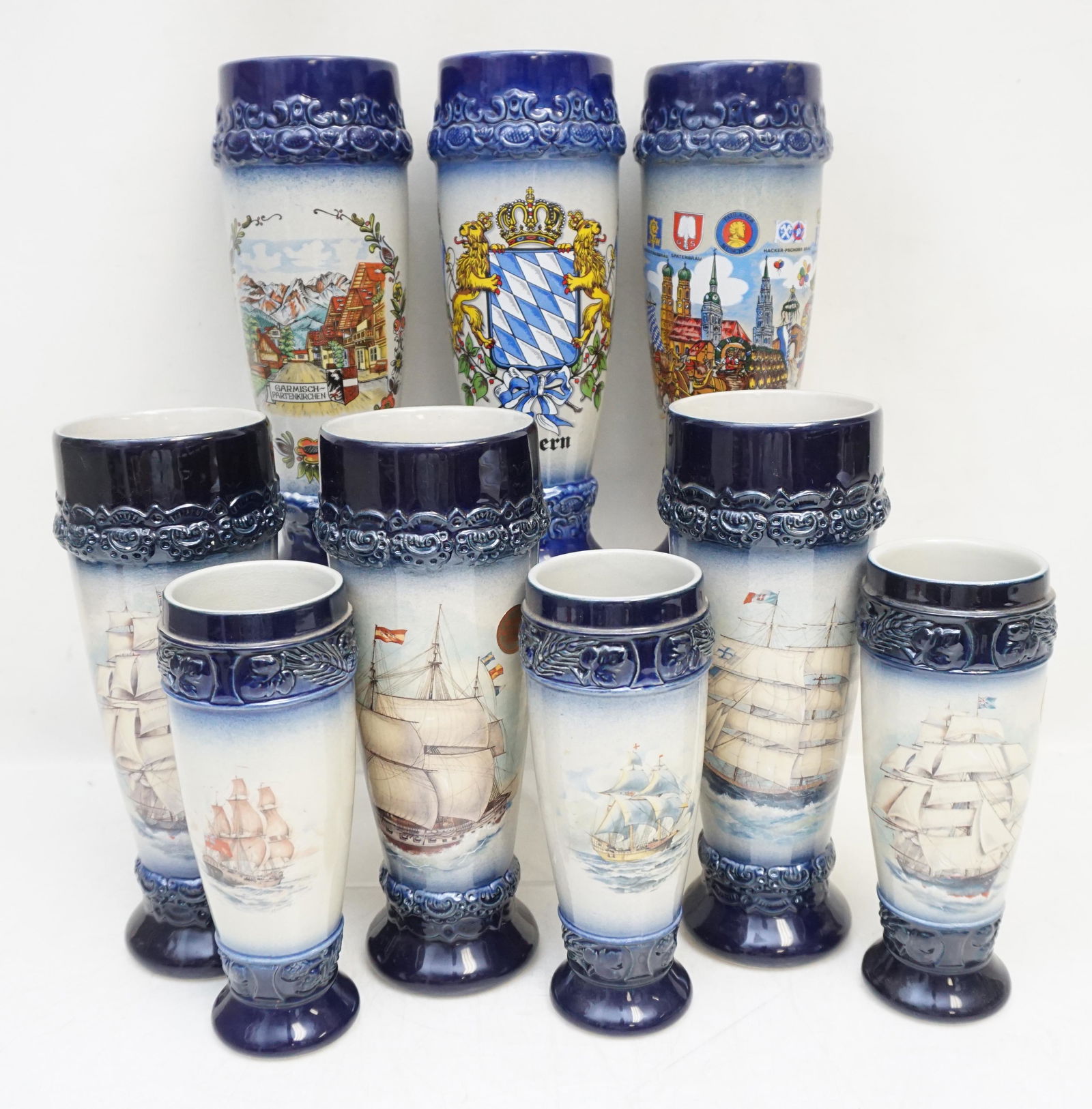 9 GERMAN STONEWARE PILSNER CUPS: 9 German Stoneware Pilsner Glasses made by King. Clipper Ship Transfer Decorated. 6 Taller 9 1/4" and 3 Smaller 7 1/4". 1 Larger with chipped foot. Weight on all 12 pds 3 oz. PROVENANCE: A Private Cha