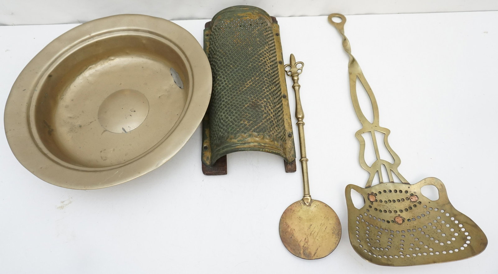 4 pc ANTIQUE BRASS GROUPING: All are Antique. 1- 18th c. Brass Basin with old repairs. 13"x13"x3". 2- 19th c. English Brass Coal Sifter with copper rivets. Measures 7"x19 1/2". 3- 19th c. English Brass Hand Forged Salamander 14 1