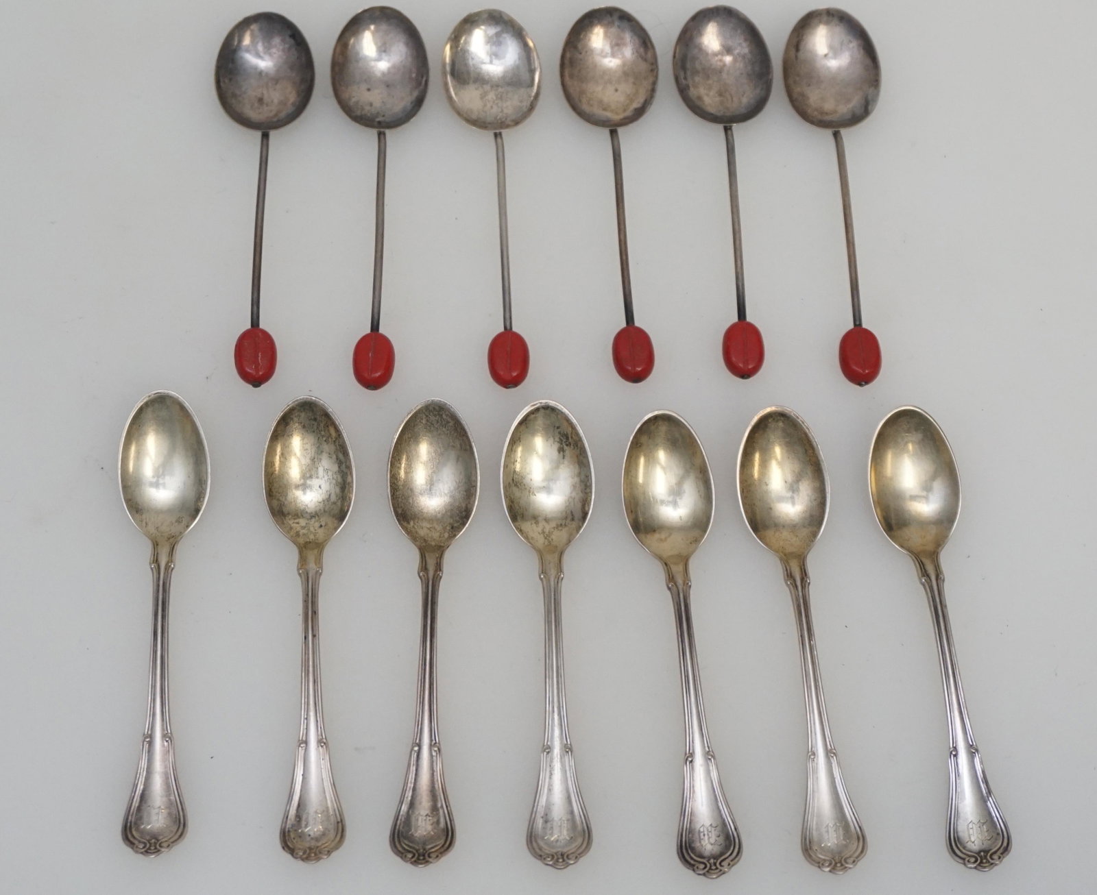 13 STERLING SILVER DEMITASSE: 6 English Birmingham Sterling Art Deco Demitasse Spoons with Red Bakelite Coffee Bean Finials. 7 Gorham Sterling Demitasse Spoons, monogrammed 3 3/4". Weight on all 90 grams. PROVENANCE: A Private Cha