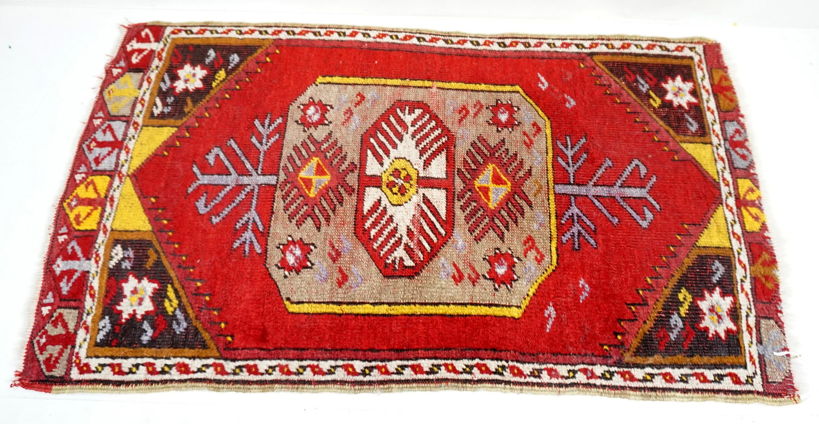 SEMI ANTIQUE HAND KNOTTED TURKISH RUG: Small Antique Early 20th c. Hand Knotted Wool Turkish Rug. Red Field. Measures 18"x31". Weight 1 pd 8 oz. PROVENANCE: A Charleston SC Private Estate.