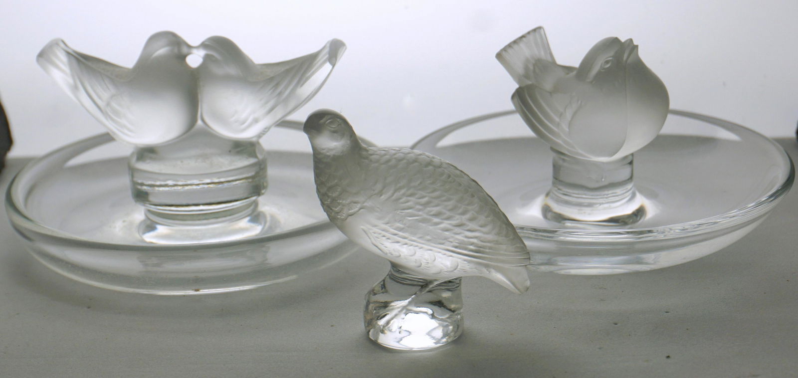 3 pc LALIQUE CRYSTAL RING DISHES + PARTRIDGE: All are signed Lalique Crystal. 1- Small Partridge / Quail Figure 2 1/4". 2- Lovebirds Ring Dish 3 1/2". 3- Sparrow Ring Dish 3 1/2". All in good condition. Weight combined 15.6 oz. PROVENANCE: A Char