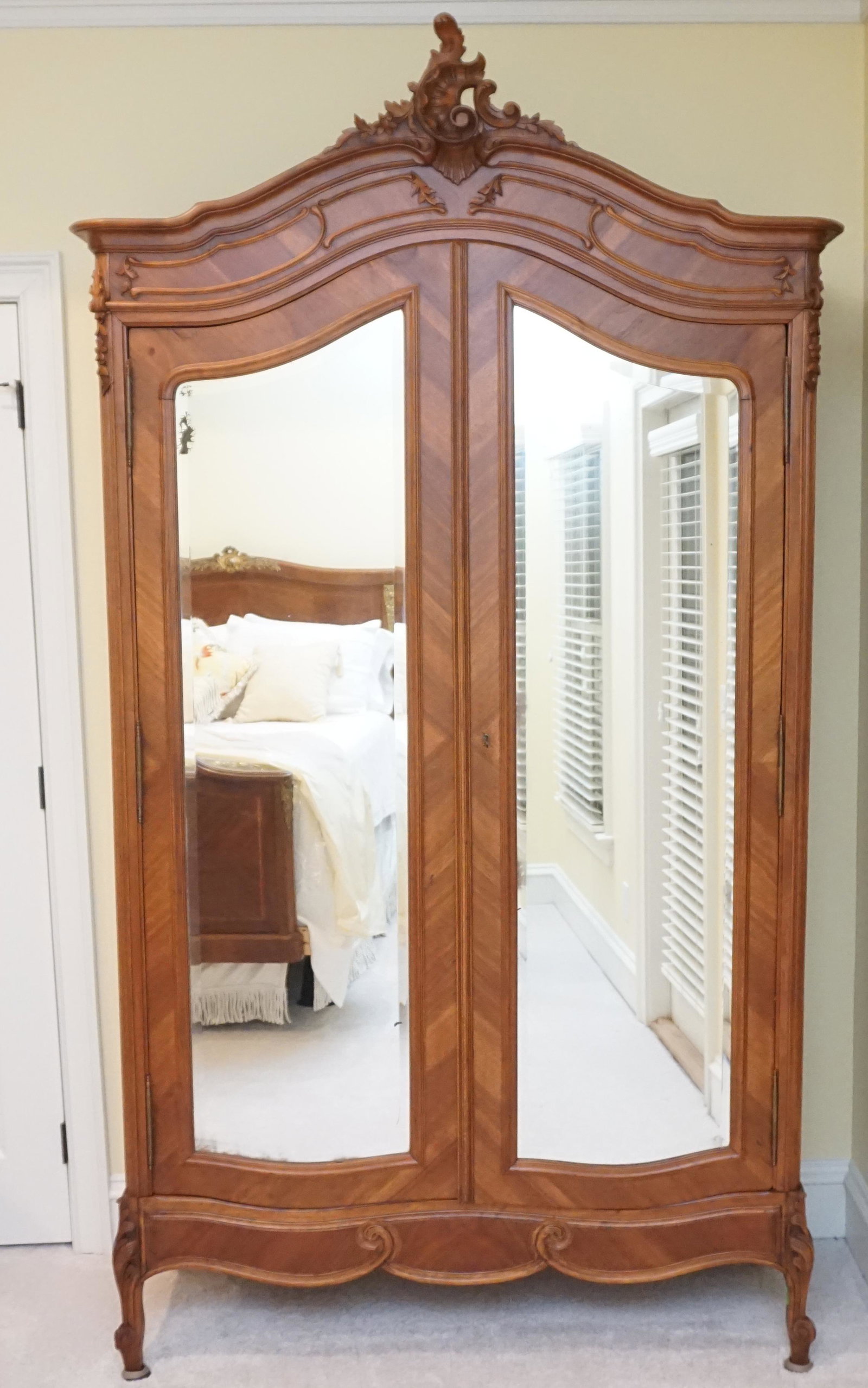 ANTIQUE LOUIS XV FRENCH ARMOIRE: Large Antique French Armoire. Louis XV Style double door French armoire with two beveled mirror doors and carving to the top, key included. Breaks apart for moving . Measures 49"x18"x96" tall. NO IN H