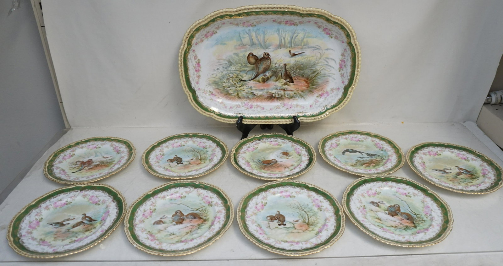 10 PC PORCELAIN GAME SET AUSTRIA IMPERIAL CROWN: 10 Piece Imperial Crown China Austria Porcelain Game Set. Various Game Birds with gilt decorated rims. Large platter 18 1/2"x13". 9 Plates 8 3/4". Condition: Good witch Nick to 1 plate rim.The Imperia