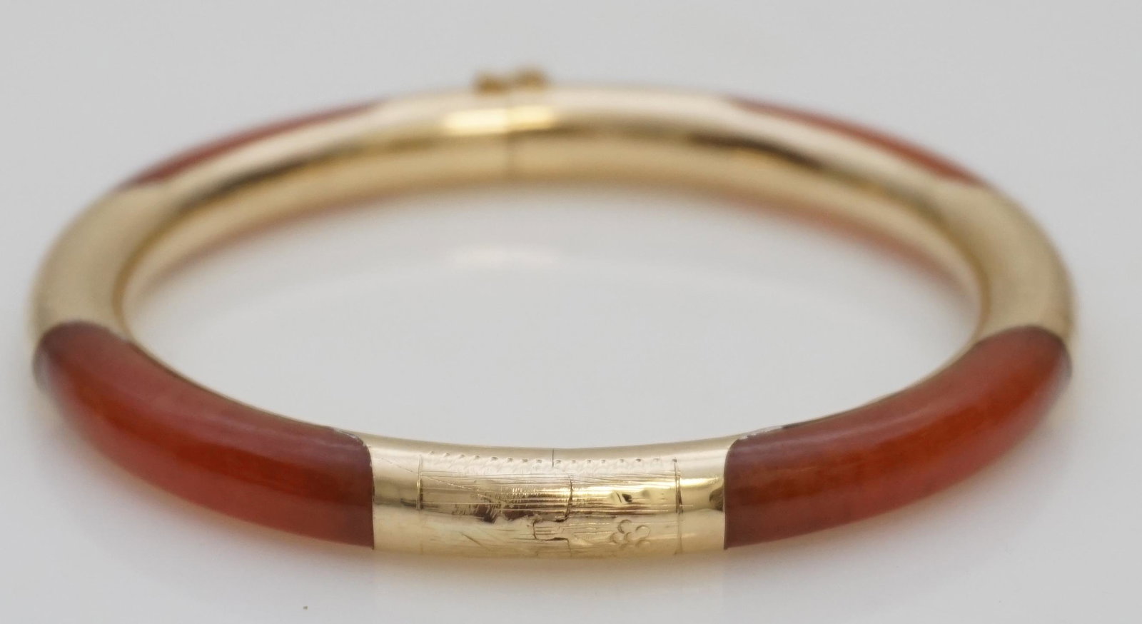 NATURAL CARNELIAN 14K GOLD BANGLE BRACELET: Mid Century Natural Carnelian and 14K Gold Hinged Bangle Bracelet. It is in good condition circa mid century 1950. The inside clasp reads 14K 585. Safety Clasp with chain. 2 1/4" inside bangle, 2 3/4"