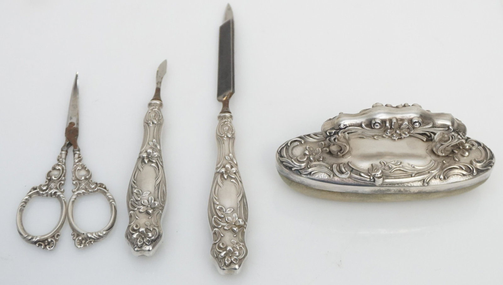 4 pc ANTIQUE STERLING SILVER MANICURE SET: 4 Pc Sterling Silver Handle Manicure Set. File, Cuticle and Buffer all by William B. Kerr. The scissors with sterling handle are made in Germany. File 6 3/4". Weight on all 5 oz. PROVENANCE: A Private
