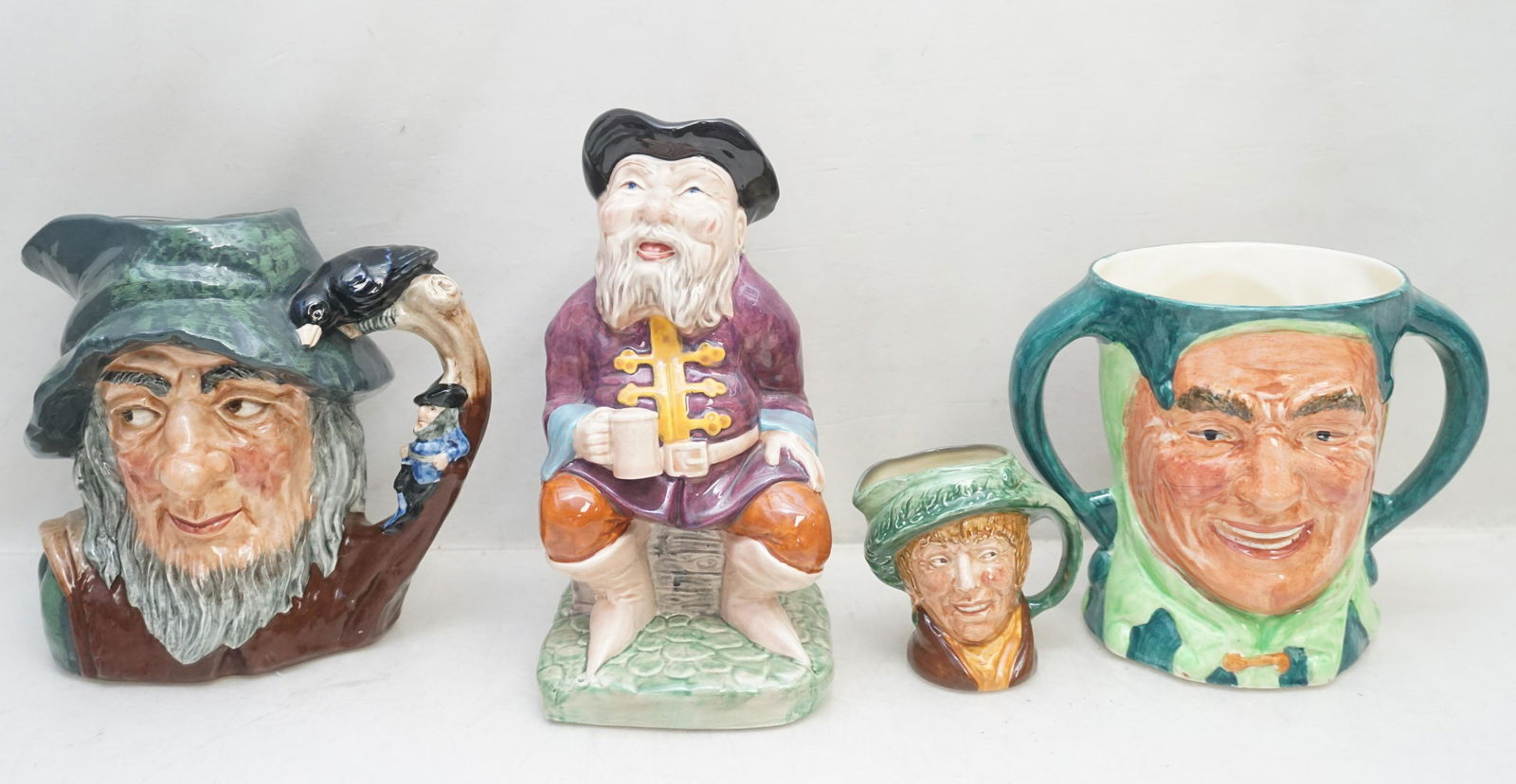 4 VINTAGE TOBY / CHARACTER JUGS / MUGS: 1- Lancaster And Sons Limited Two Faced Joker 5 3/4". 2- Melba Ware Tale Teller 8 1/2". 3- Royal Doulton Rip Van Winkle 7 1/2". 4- Royal Doulton Miniature Toby "Arriet" 3". Weight on all combined 5 pd