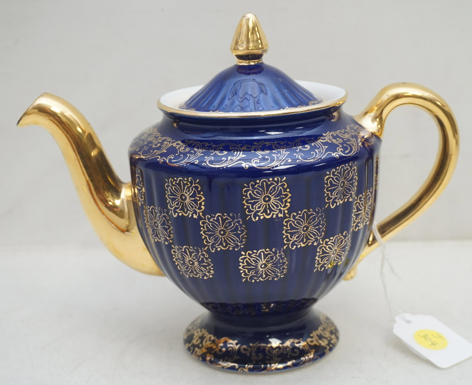 VINTAGE HALLS COBALT TEAPOT: Vintage Halls Pottery Cobalt and Gilt Tea Pot. Very good condition. Measures 9 1/2" long and 7 1/2" tall. Weight 2 pds 2 oz. PROVENANCE: A Private Charleston SC Estate.