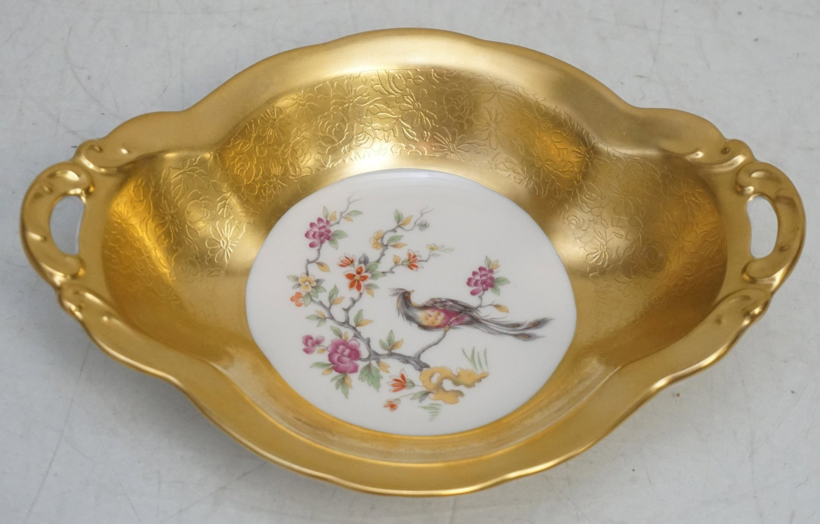 PICKARD BIRD OF PARADISE GILDED DISH: Vintage Pickard Bird of Paradise Chinoiserie Handled Dish with Gold Rose & Daisy Pattern Sides. Pickard developed a process to cover much or all of a piece with gold in 1911. It was called the Rose an
