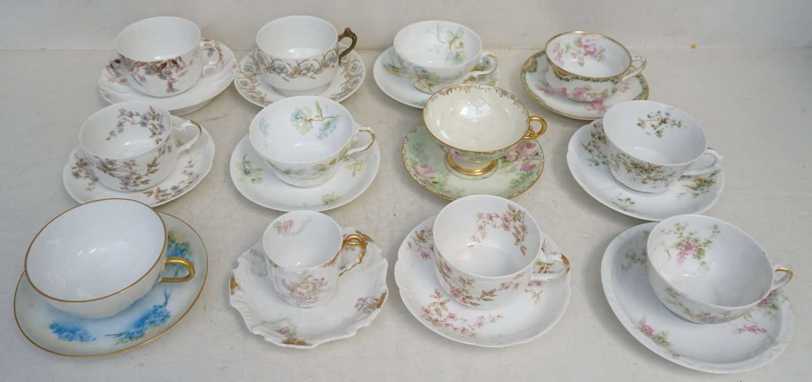 12 ANTIQUE PORCELAIN TEACUPS + SAUCERS: 12 Antique Porcelain Teacups and Saucers. Mostly Limoges. Various Florals. Good condition. Weight on all 6 pds. PROVENANCE: A Private Charleston SC Estate.