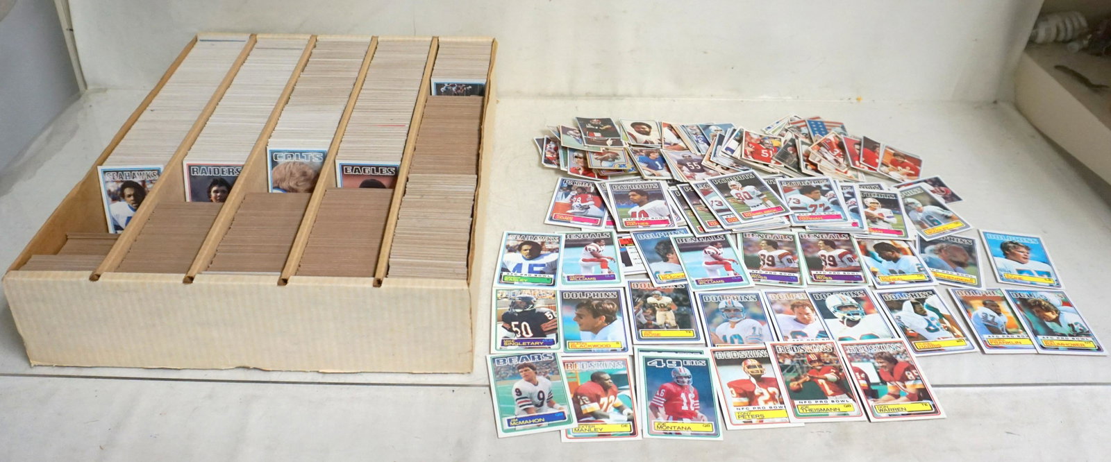 1983 TOPPS FOOTBALL CARDS: 1983 Topps Football cards & more. Featured rookie cards include Jim McMahon, Joe Montana, Reggie Williams, Ken Easly, Dexter Manley, Mike Singletary. Several duplicates. New old stock. Weight 18.15lbs