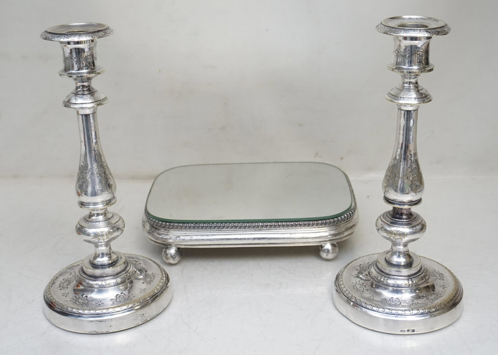 ANTIQUE SILVERPLATE PLATEAU & CANDLESTICKS: Antique Silverplate Mirror Plateau 8 1/2"x6". Two Etched Floral Continental Silverplate Candlesticks 9 3/4". Weight on all 3 pds 13 oz. PROVENANCE: The Estate of Dr. Fraser Wilson, Charleston SC. Dr. 