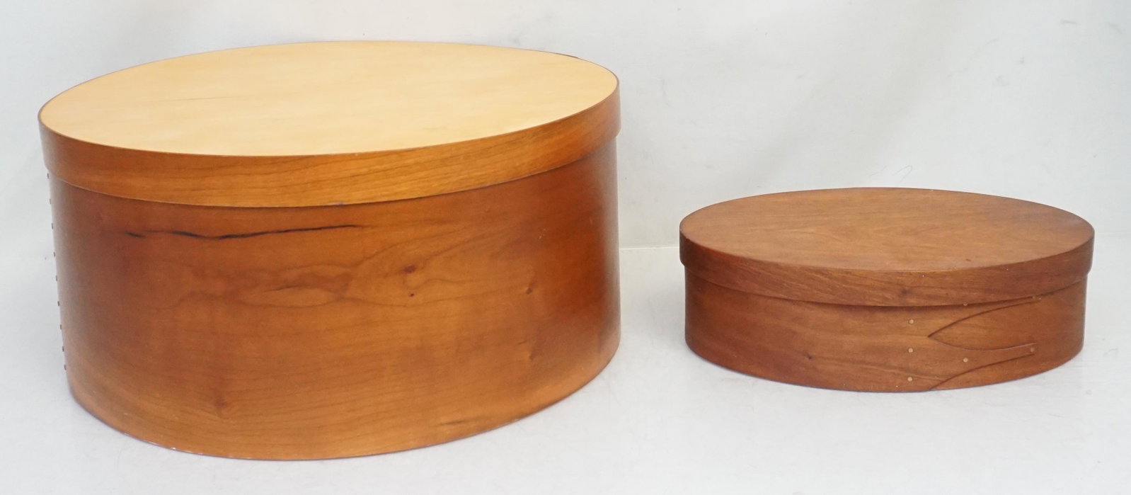 2 SHAKER STYLE BENTWOOD BOXES: 2 Shaker Style Bentwood Boxes. The smaller made by RJ Monroe in the Shaker tradition 10"x7"x3". The largest, made in Taiwan 14 1/4"x14 1/4"x6 3/4". Weight combined 2 pds 9 oz. PROVENANCE: A Private Ch
