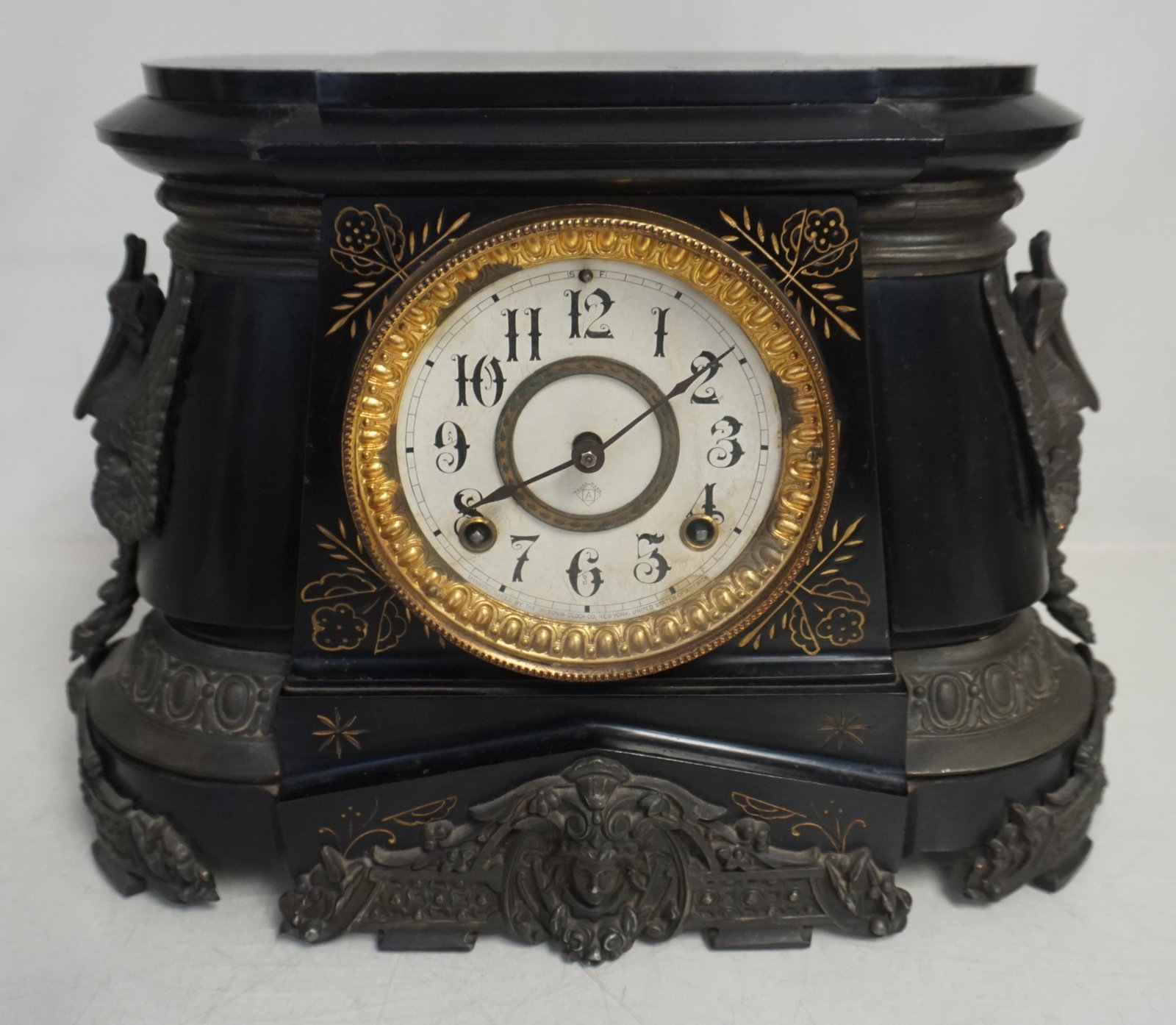 ANSONIA POMPEII MANTLE CLOCK: Ansonia Pompeii c. 1900 Enameled Iron case Mantel Clock with 8 day time and half hour gong striking movement with a 5 1/2? dial. With key and pendulum. Not tested. All clocks sold As Is, Where Is, no 