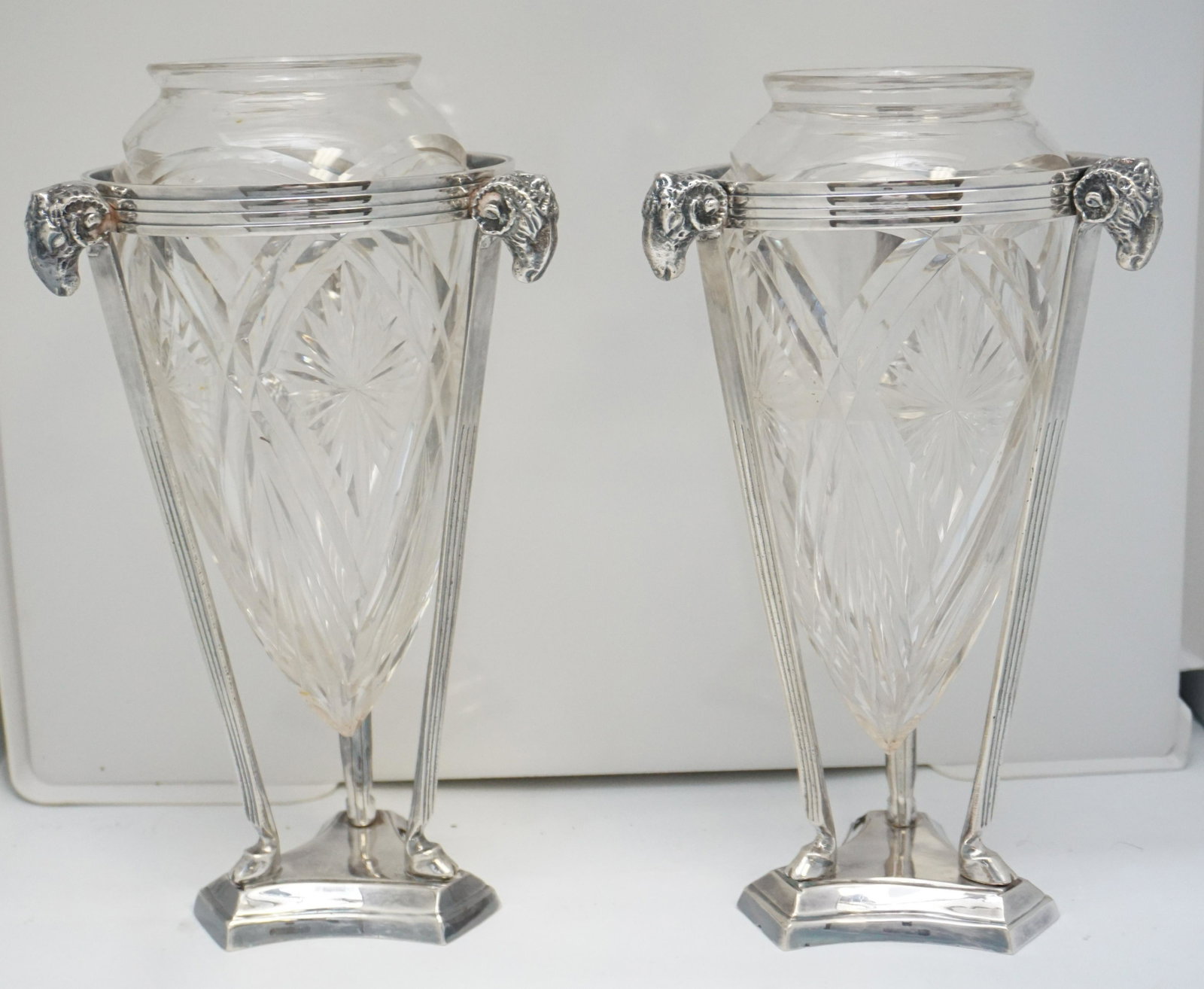 PAIR FRENCH STYLE CUT CRYSTAL VASE IN STAND: Matched pair of Antique French style cut crystal vases in Silverplate Rams Head Stands. Each 6"x6"x10 1/2". Weight 6 pds 8 oz. PROVENANCE: The Estate of Dr. Fraser Wilson, Charleston SC. Dr. Wilson wi